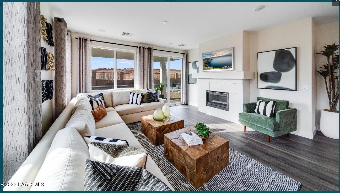 Modern living room with fireplace and sectional sofa in The Boulder II H floor plan at South Ranch, Prescott, Arizona.