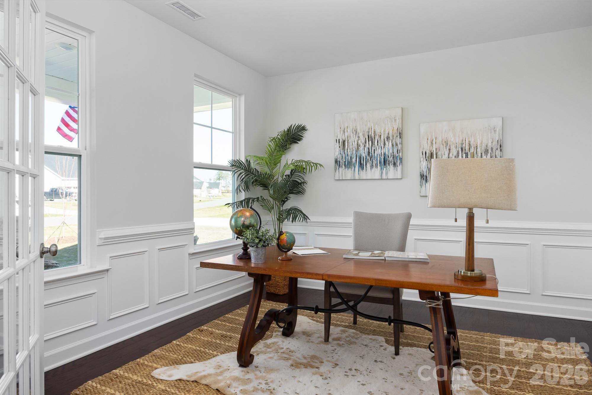 Bright home office with wood desk and wainscoting in The Hemlock D floor plan at Enclave at Belmont, Belmont, North Carolina.
