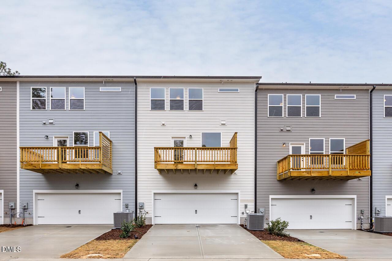 Modern 3-story townhomes with wooden balconies and 2-car garages in Camden Park, Knightdale, North Carolina