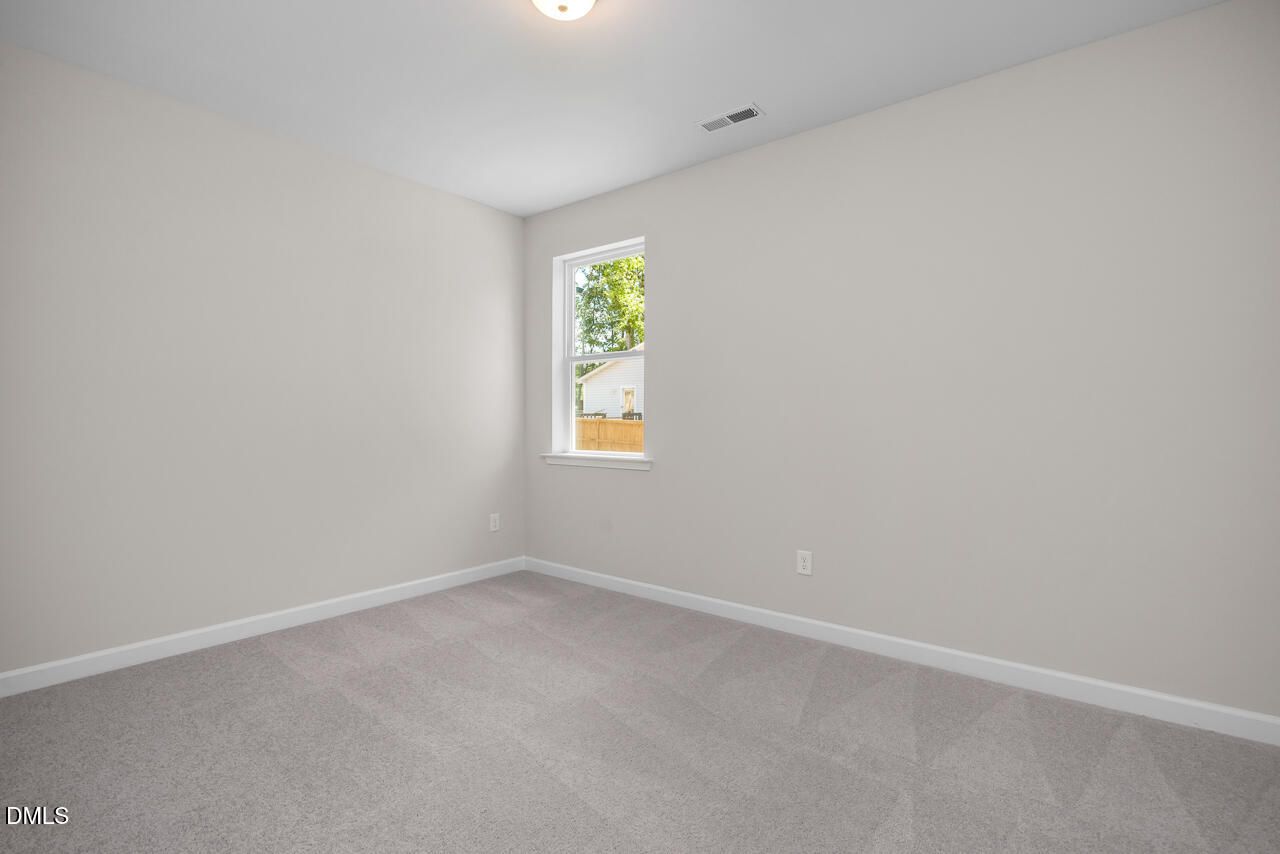 Bright, neutral-toned bedroom with plush carpeting in The Ashport G floor plan at Sage on North Main, Wake Forest, NC.