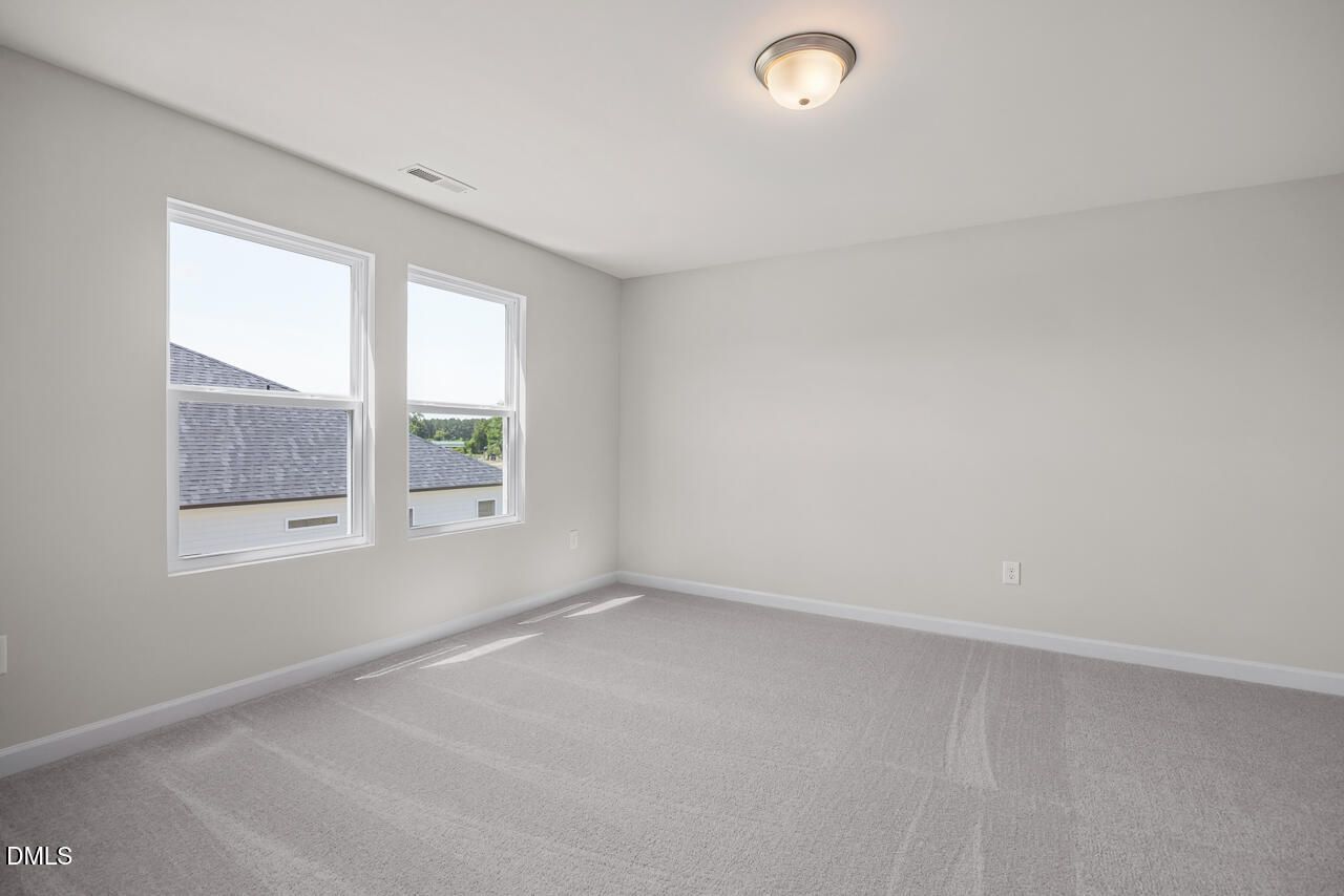 Bright, spacious secondary bedroom with plush carpeting in The Grace C floor plan at Retreat at North Main, Lillington, NC.