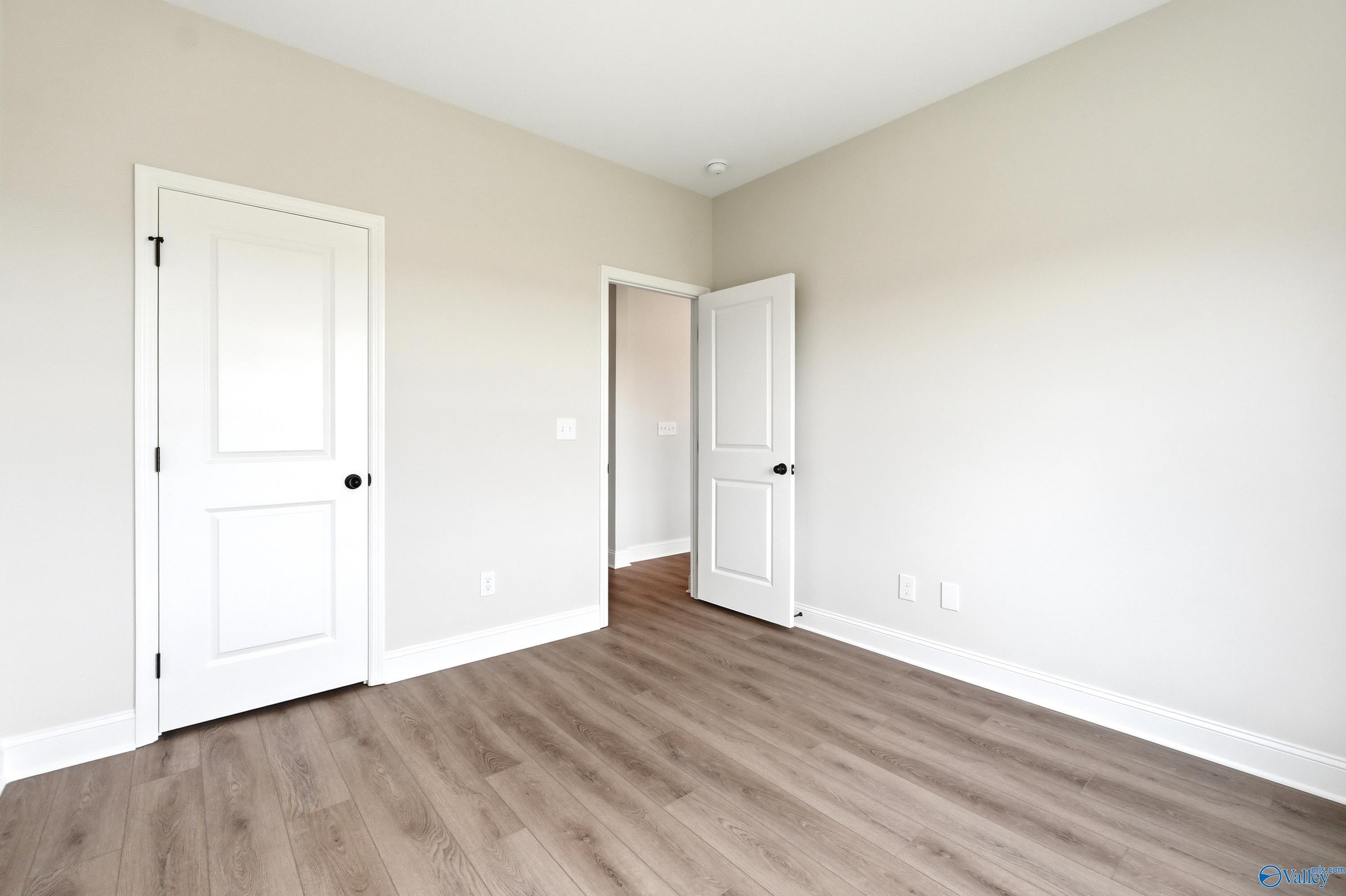 Bright, neutral bedroom with wood-look flooring in The Shelby A floor plan at Clearview in Hazel Green, Alabama.