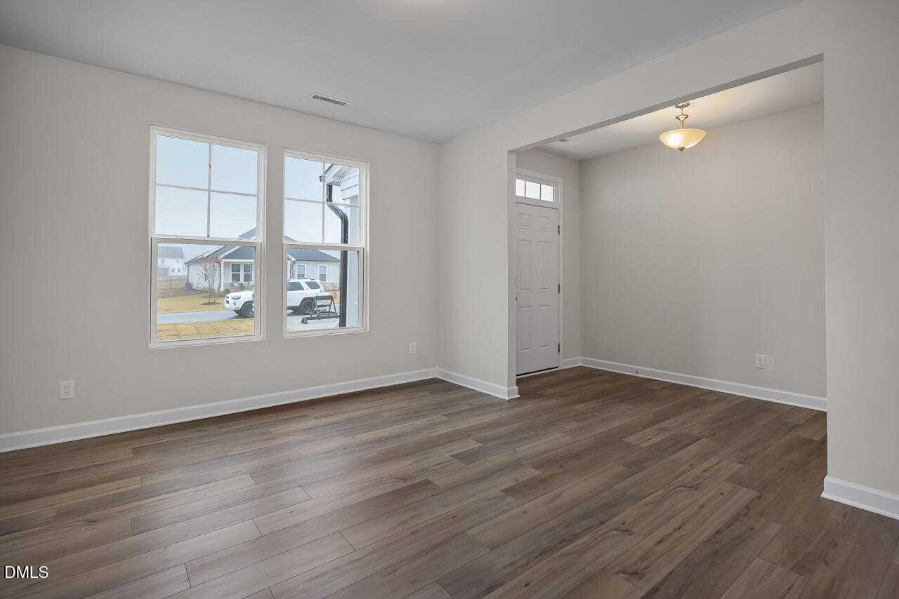 Bright entry living room with hardwood floors, large windows, and open archway in Davidson Homes The Hickory II A, Lillington, NC