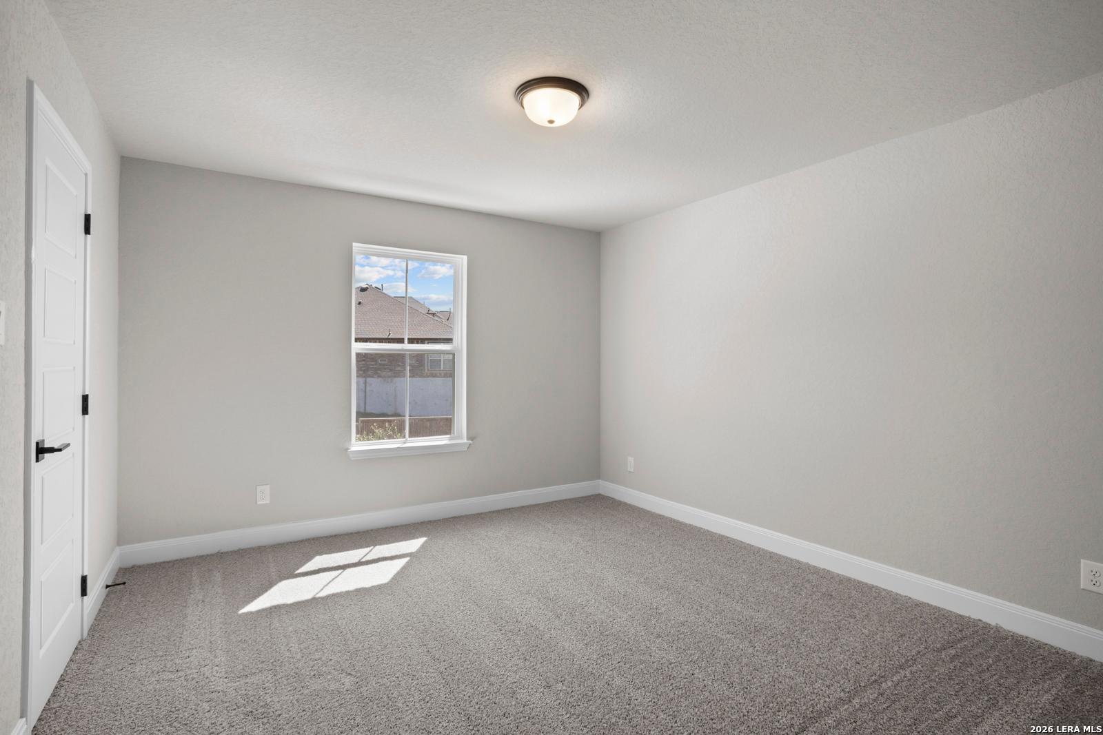 Spacious secondary bedroom with neutral carpet and paint in The Jennings G floor plan at Ladera, San Antonio, Texas.