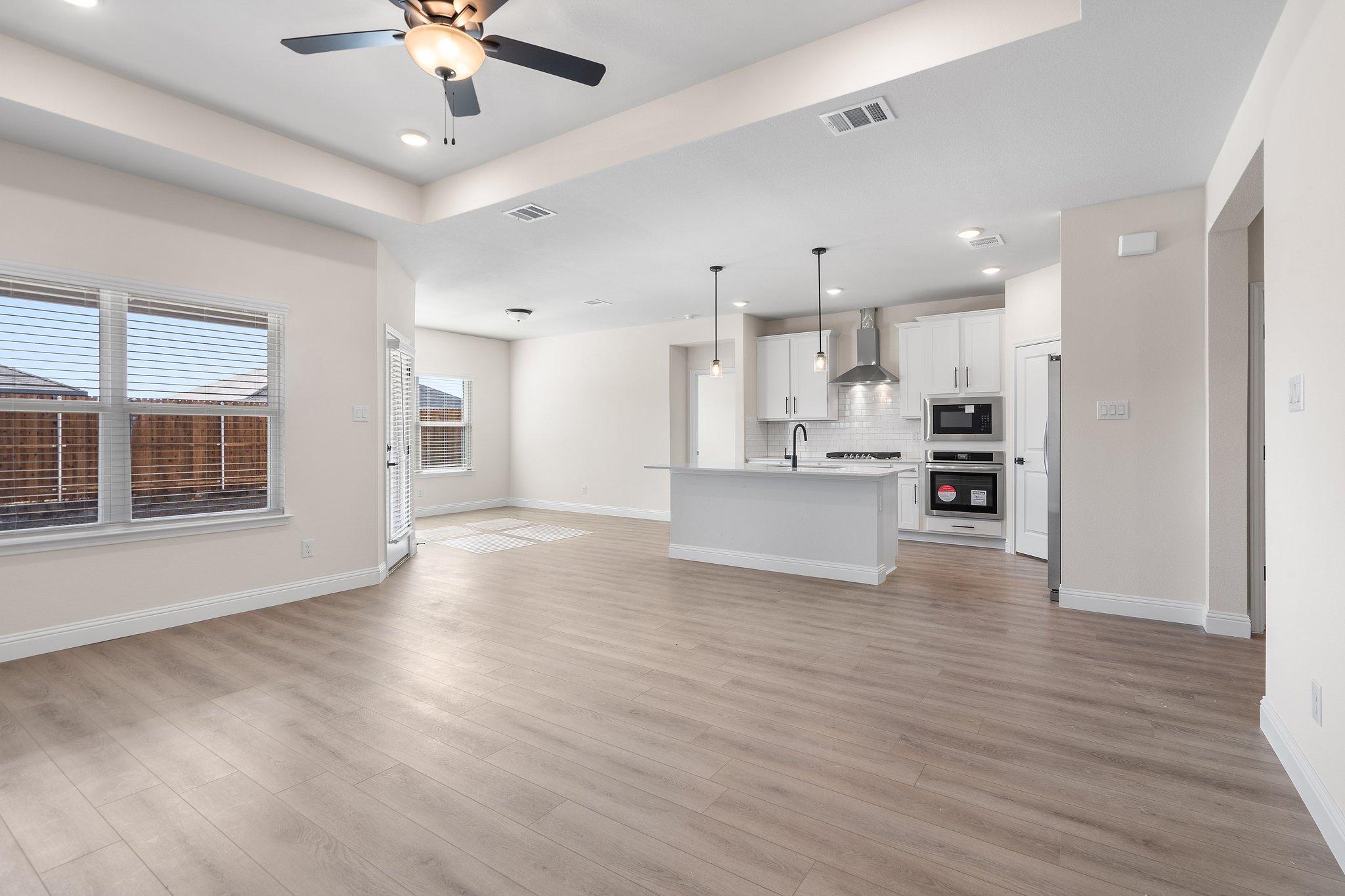 Open-concept living and kitchen area in The Holly floor plan featuring a center island and modern finishes.