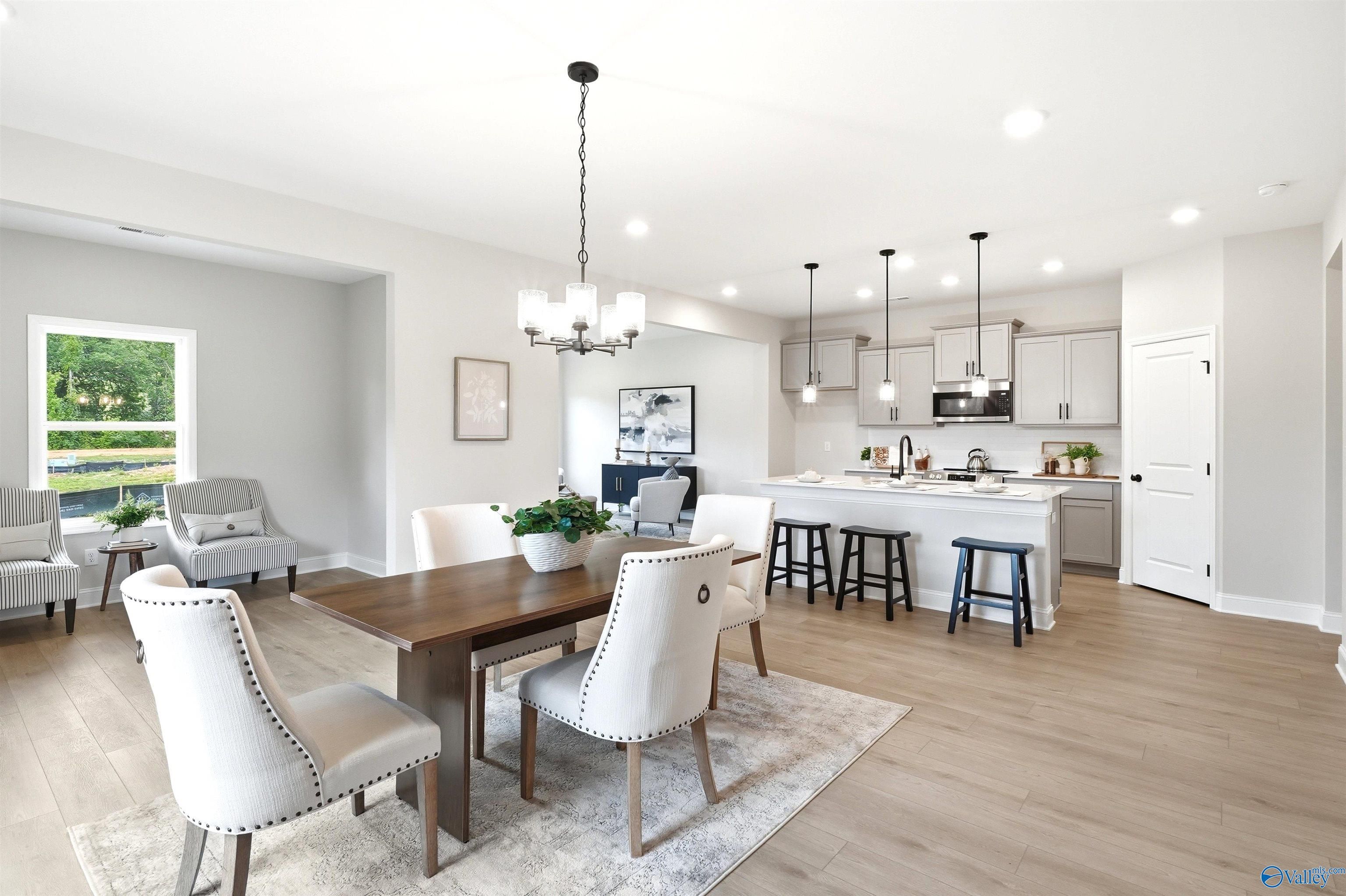 Open-concept dining area with kitchen island and pendant lighting in Davidson Homes' The Russell A floor plan at Spragins Cove, Huntsville.