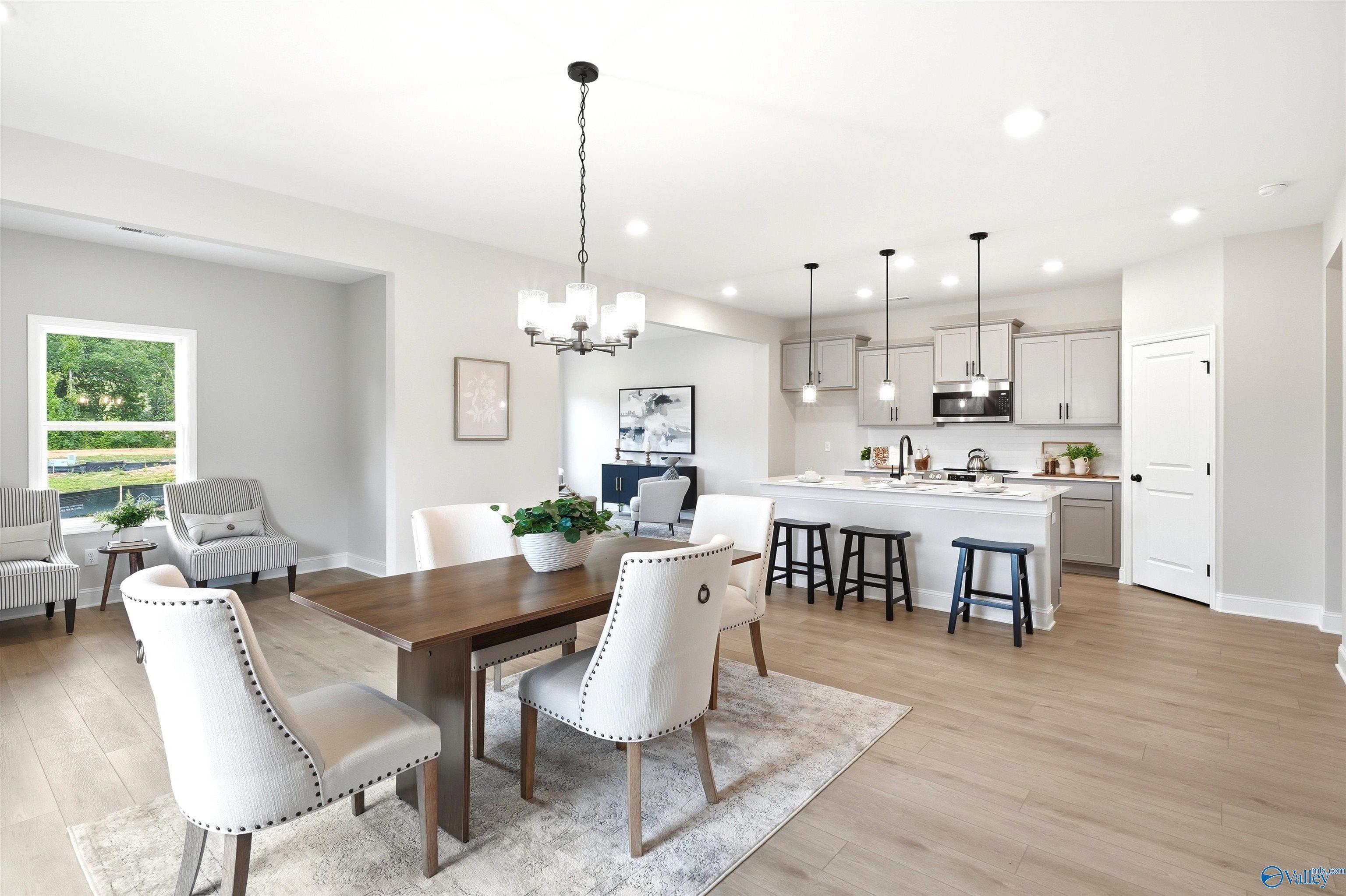 Open-concept dining area with kitchen island and pendant lighting in Davidson Homes' The Russell A floor plan at Spragins Cove, Huntsville.