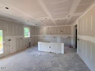 New construction interior with coffered ceiling and kitchen island in Hickory II B floor plan, Woodland Crossing, Zebulon.