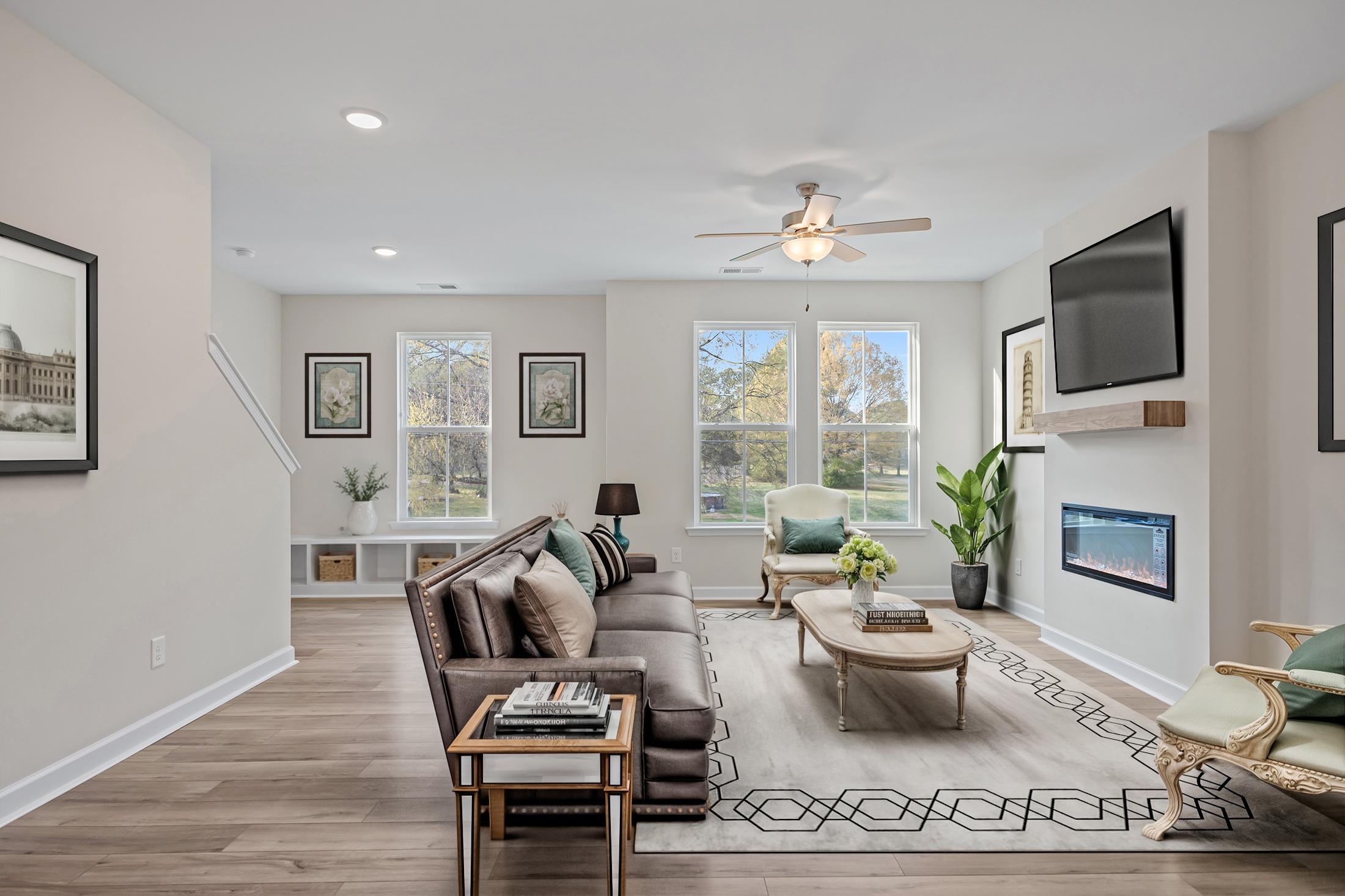Spacious open-concept living area in The Avery featuring a modern fireplace, stylish furniture, and hardwood-style flooring.