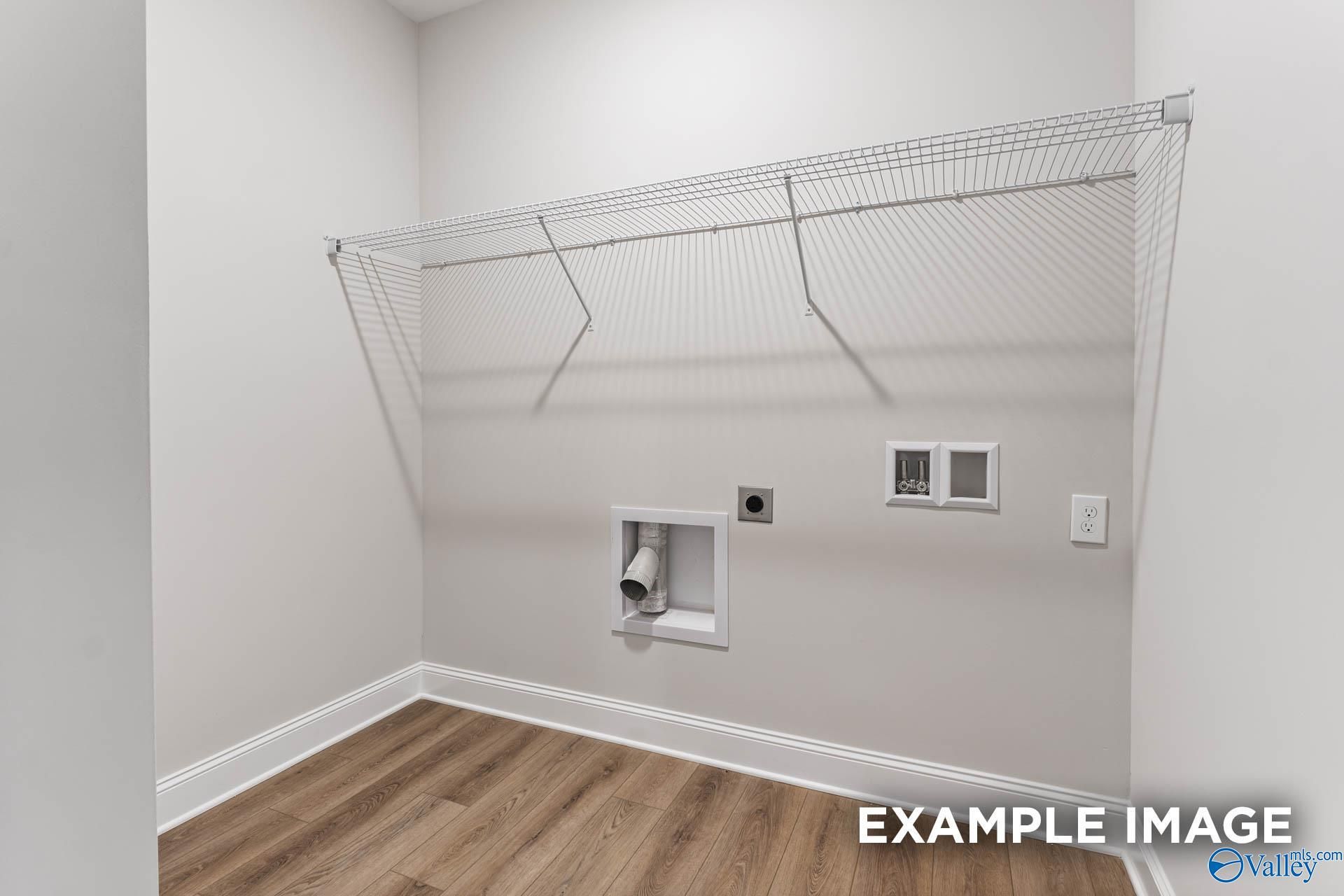 Spacious laundry room with wire shelving, washer-dryer hookups and hardwood floors in Davidson Homes The Daphne C, Arab, Alabama