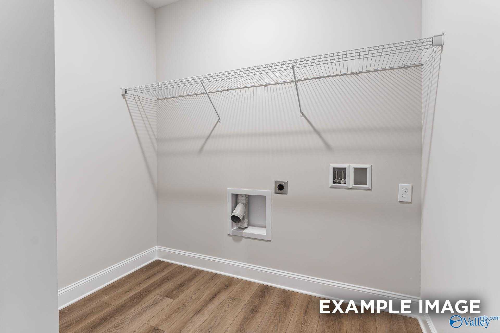 Spacious laundry room with wire shelving, washer-dryer hookups and hardwood floors in Davidson Homes The Daphne C, Arab, Alabama
