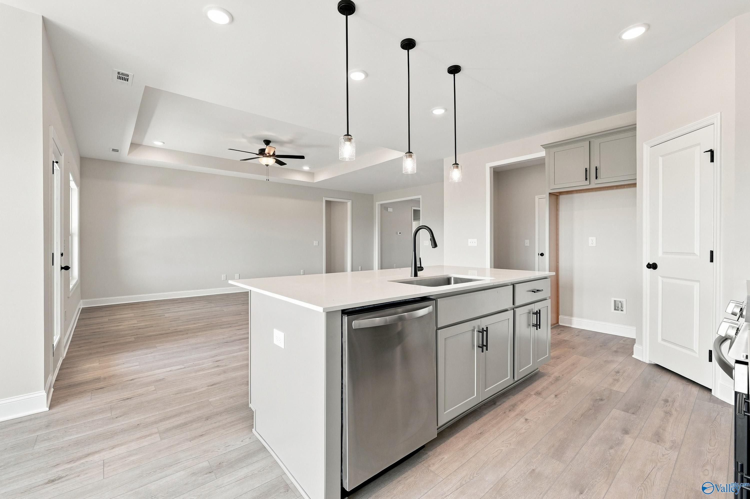 Kitchen island with pendant lights and stainless dishwasher in Davidson Homes Montgomery D floor plan, Anderson Farm, Athens, AL