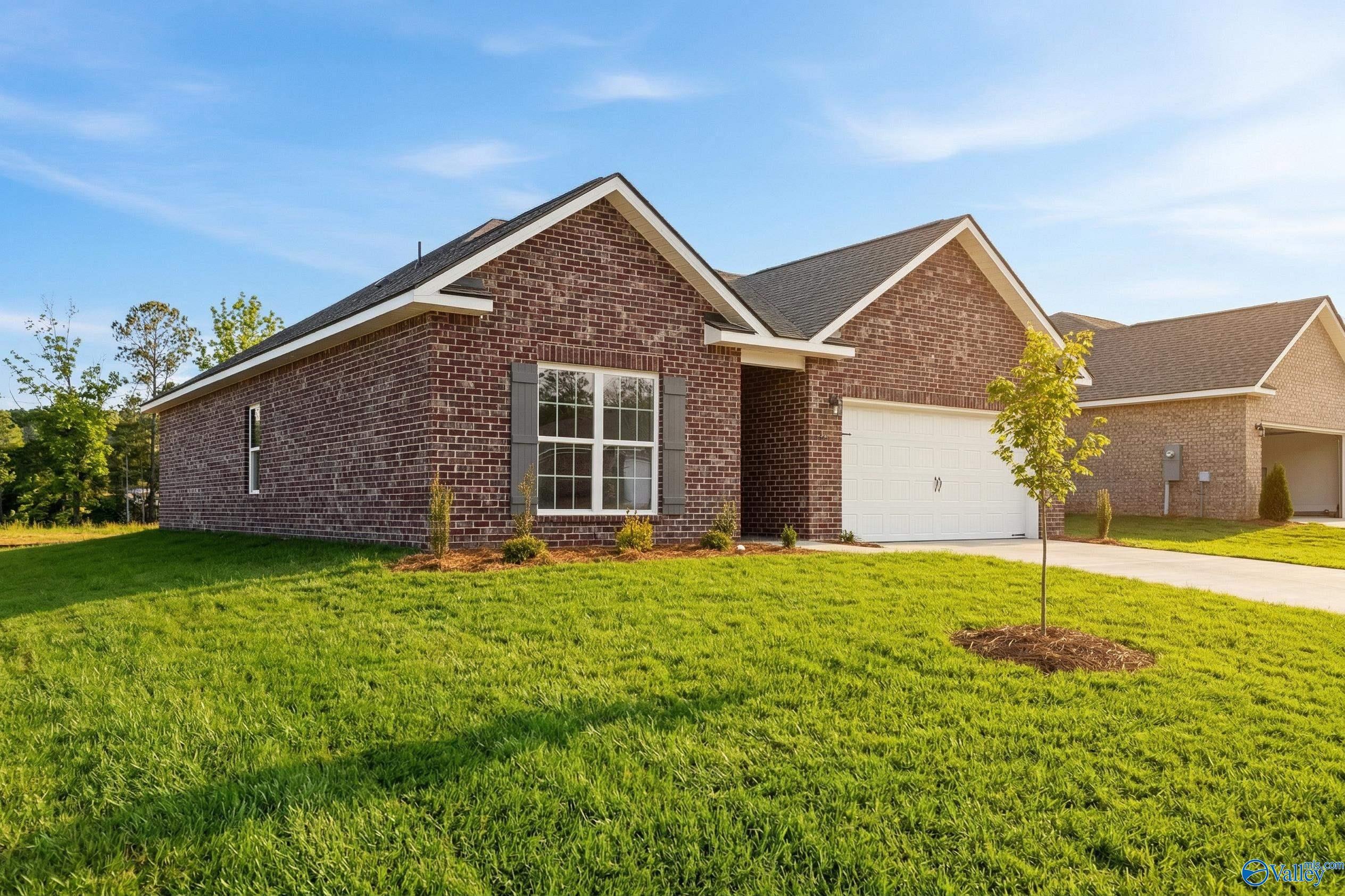 Brick single-story home with 2-car garage, red brick exterior, and lush front yard in Spragins Cove, Huntsville, Alabama - Davidson Homes The Asheville C