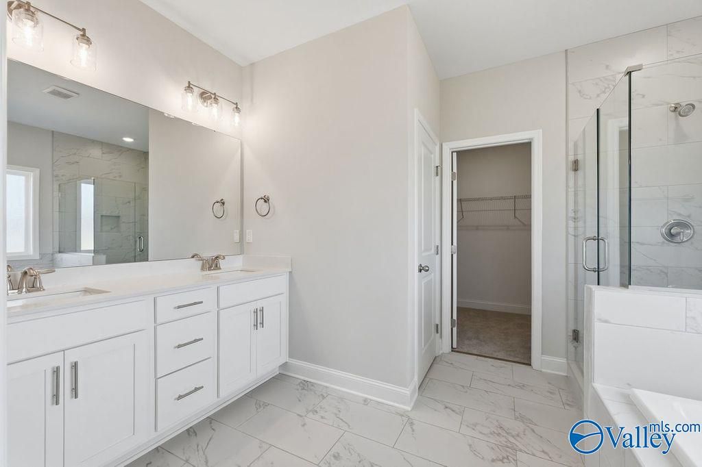 Elegant master bathroom with double vanity, frameless glass shower, soaking tub in Davidson Homes The Harrison, Hartselle, AL