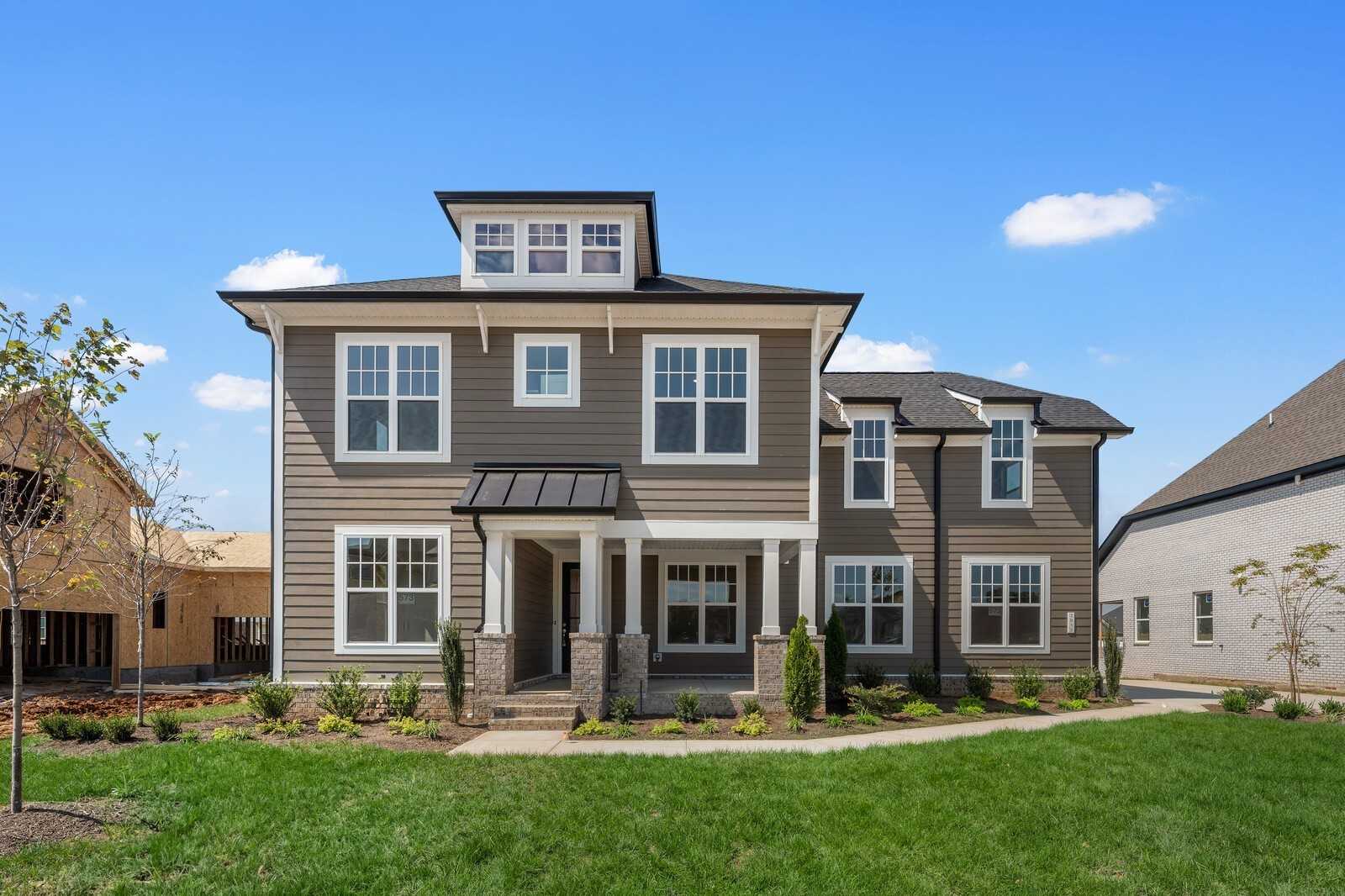 Modern two-story gray home with white trim, columned porch, and landscaped yard in Shelton Square, Murfreesboro, Tennessee - Davidson Homes The Hathaway