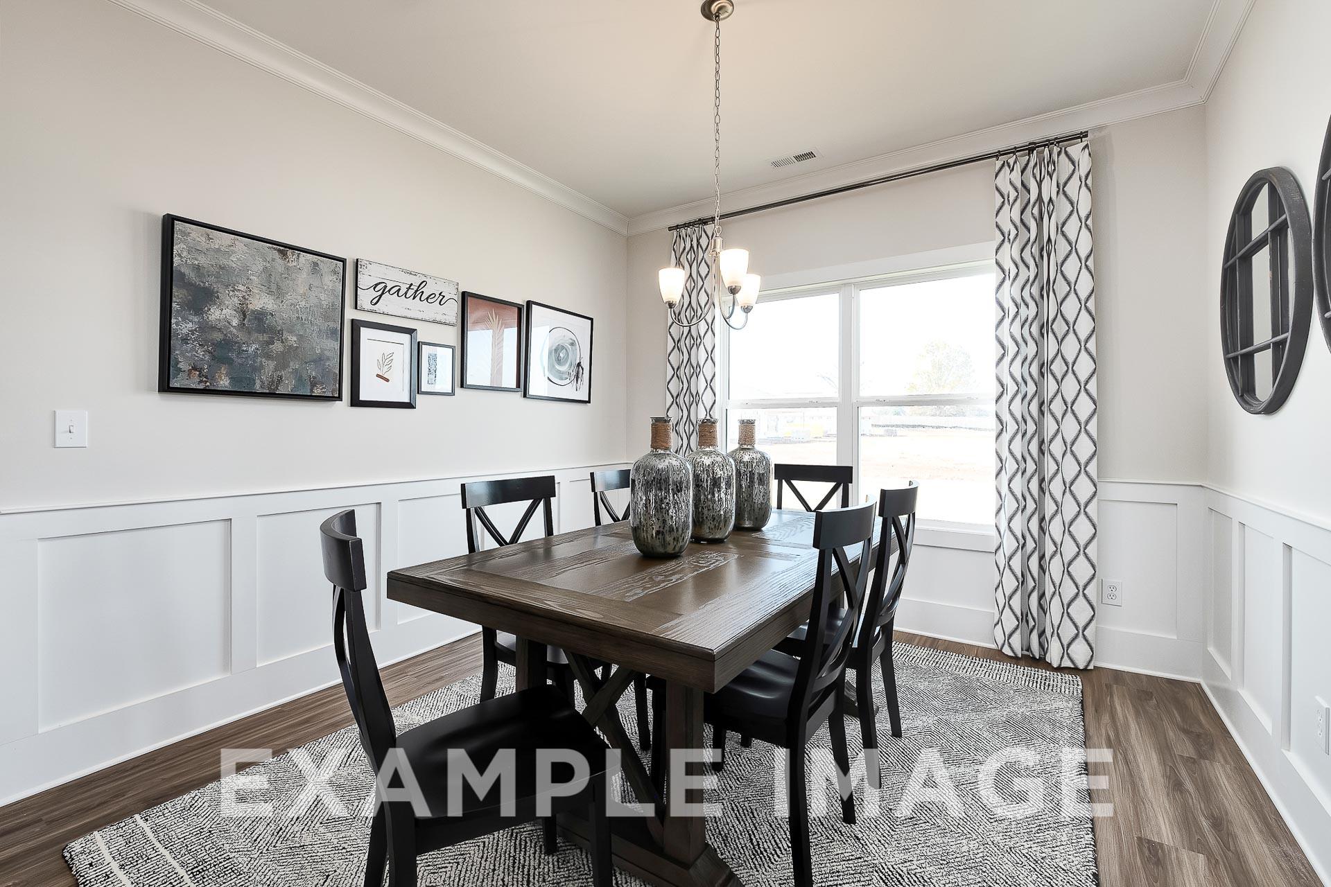 Spacious dining room in The Everett B Davidson Homes design featuring wooden table, upholstered chairs, chandelier, and wall art