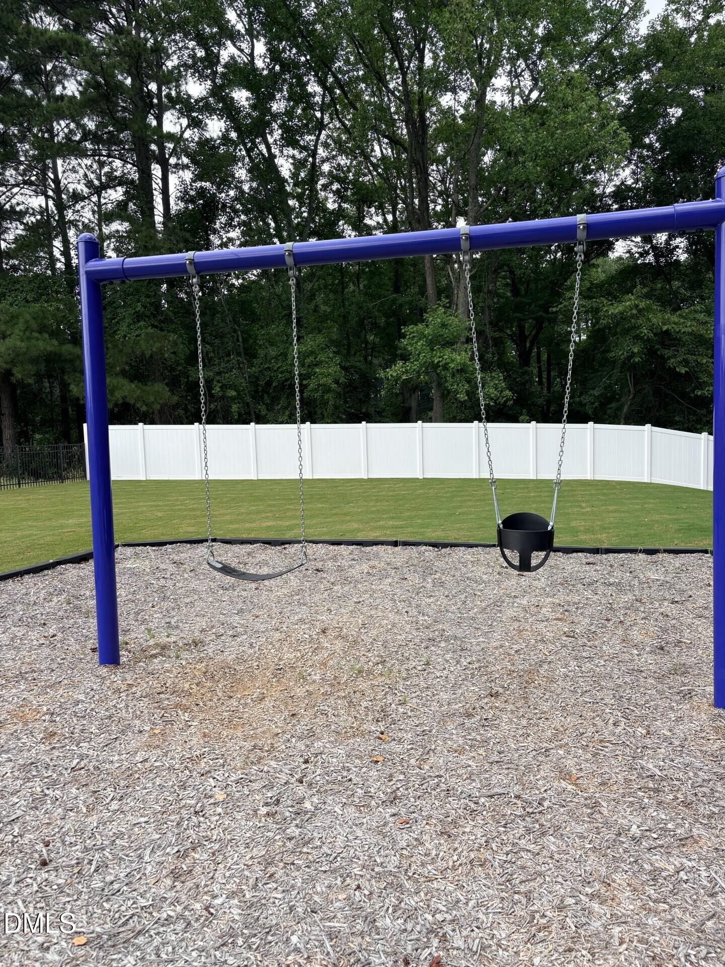 Playground with swings in the community park at Woodland Crossing, Zebulon, North Carolina by Davidson Homes.