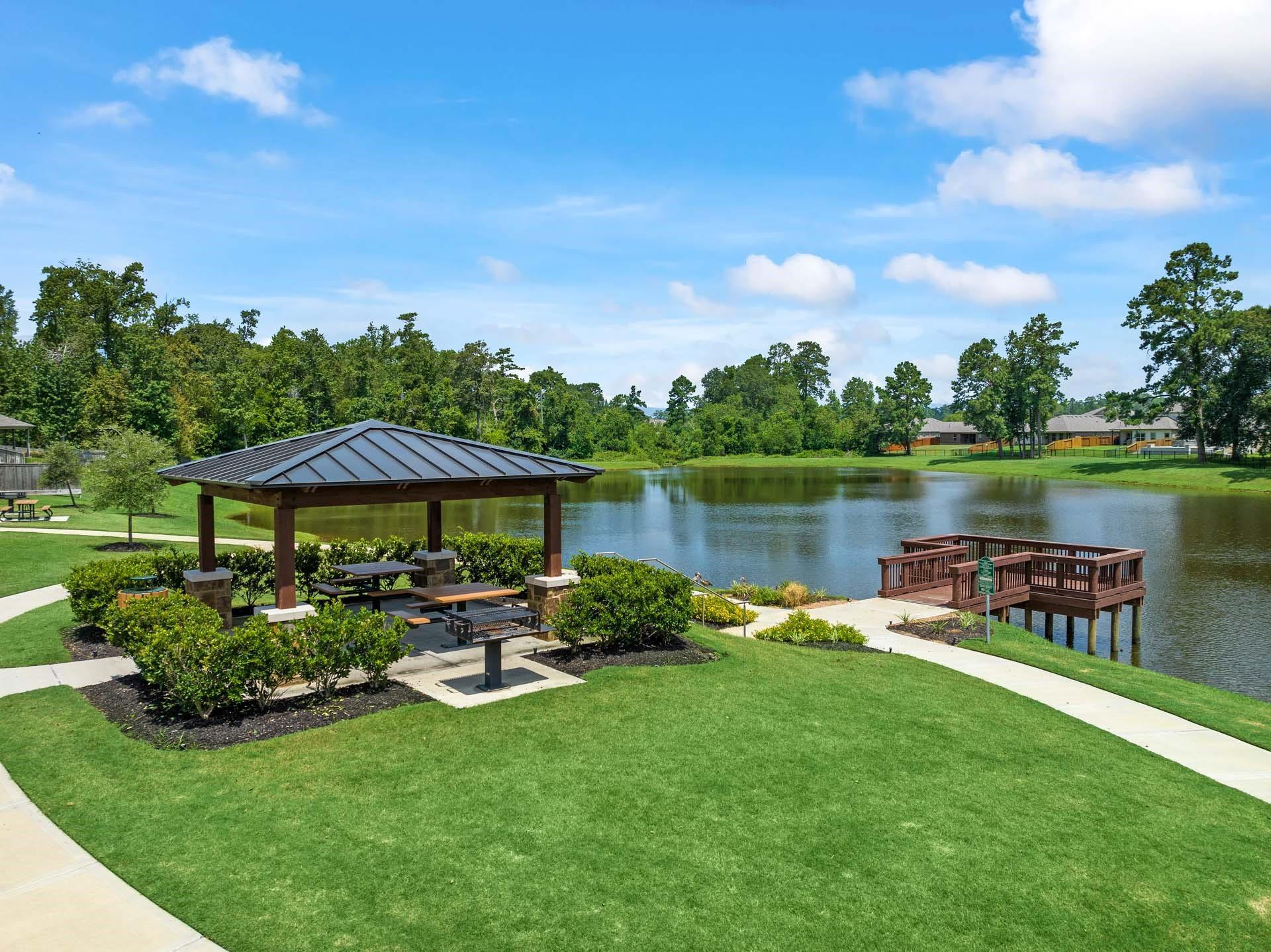 Serene lakeside gazebo with picnic tables and wooden dock in Lakes at Black Oak, Magnolia, Texas