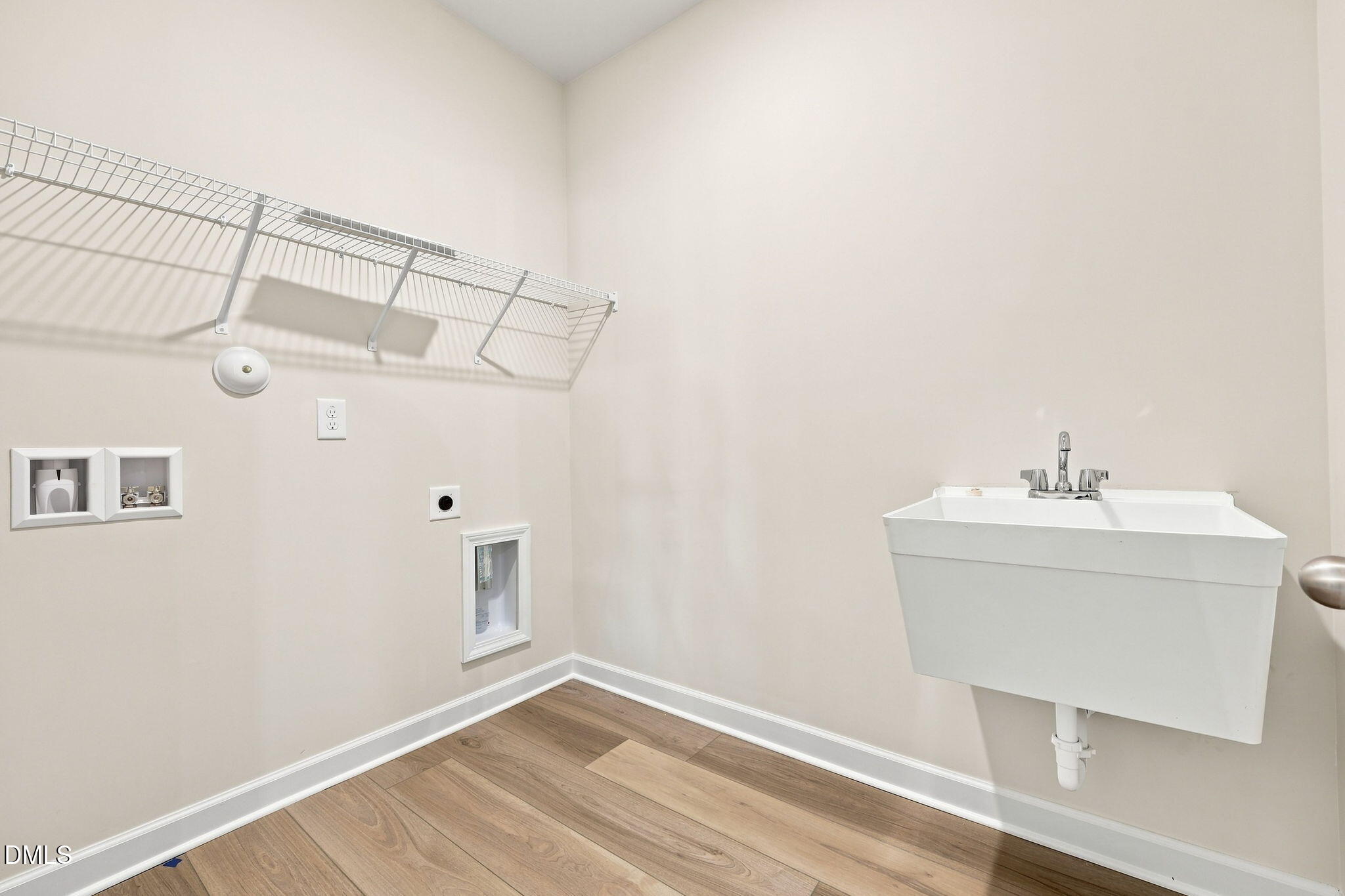 Laundry room with utility sink and shelving in The Magnolia B floor plan at Retreat at North Main in Lillington, NC.