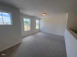 Spacious carpeted loft area in The Willow B floor plan by Davidson Homes at Woodland Crossing in Zebulon, North Carolina.