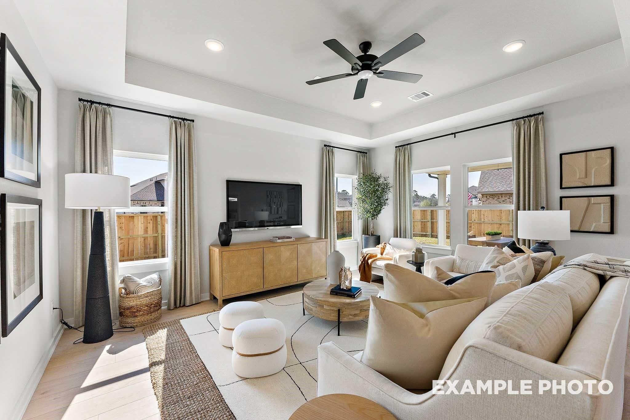 Bright, open-concept living room with tray ceiling in The Everett E floor plan by Davidson Homes in Crosby, Texas.