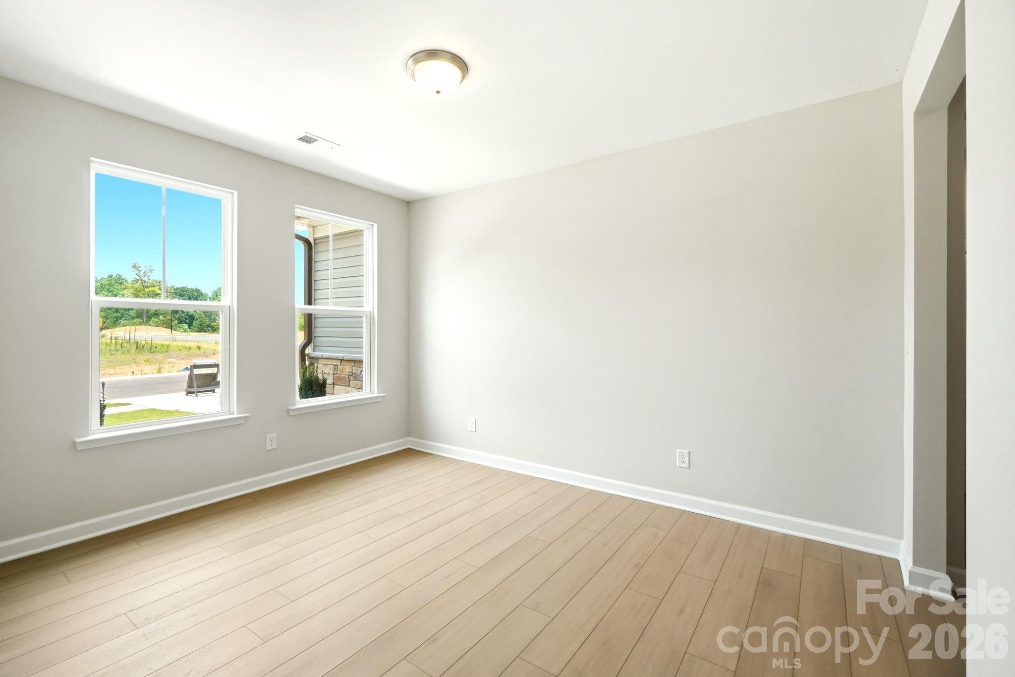 Bright, spacious bedroom with light hardwood floors in The Magnolia B floor plan at Windgate in Mooresville, NC.