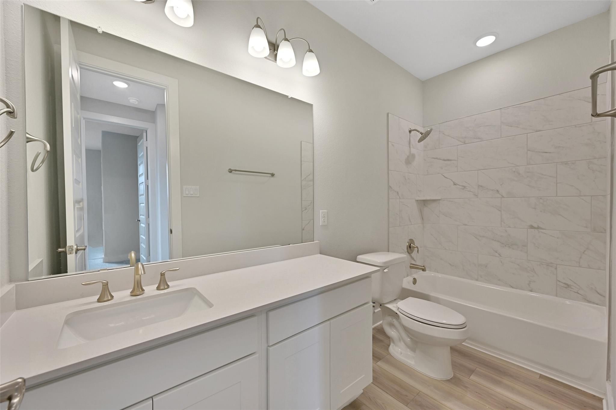 Modern bathroom with double white vanity, quartz countertop, subway tile shower, soaking tub in Davidson Homes The Edward A, Lago Mar, Texas City