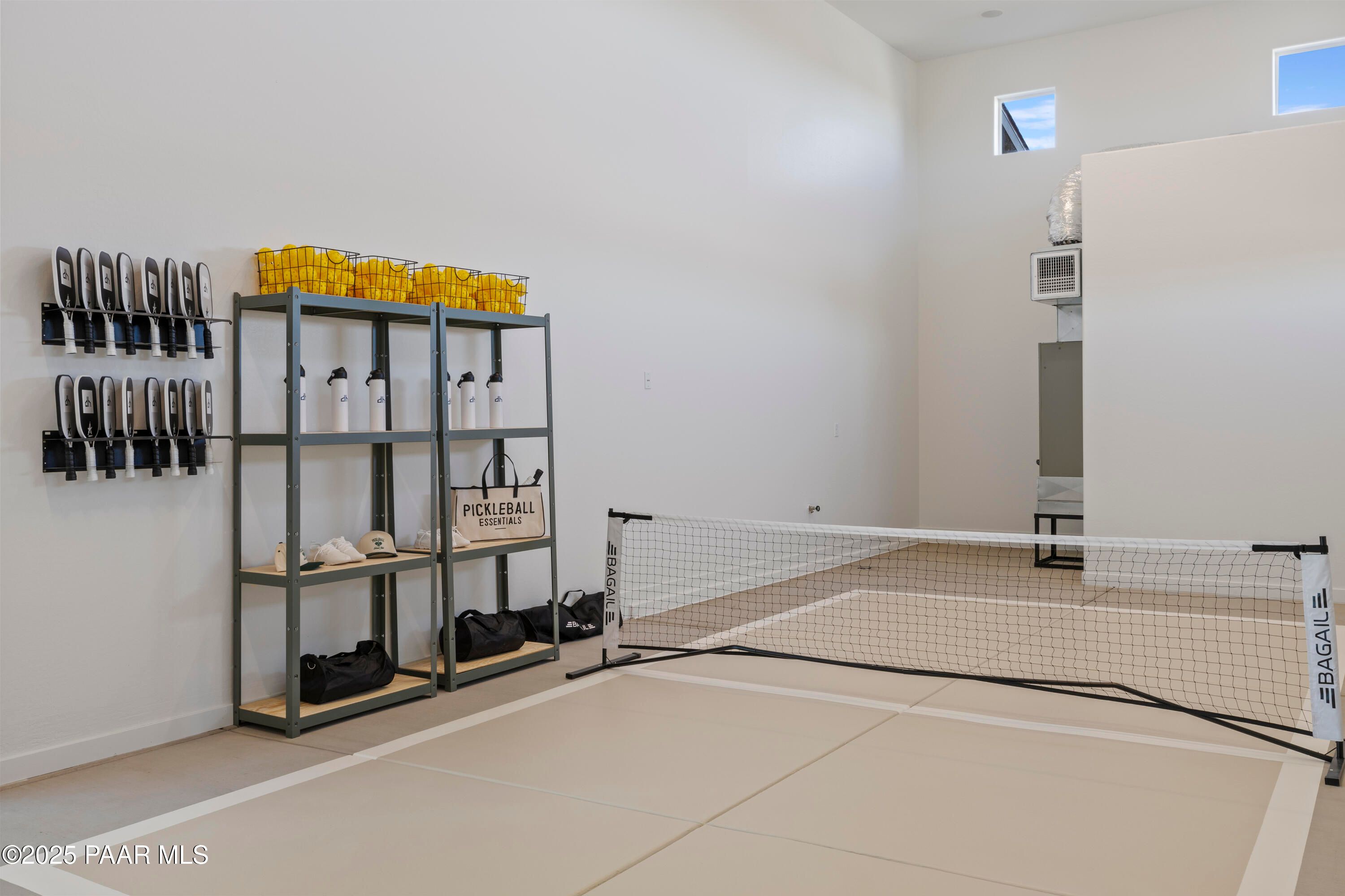 Indoor pickleball court with net, paddles, balls and shelves in Davidson Homes The Blaze D, Hidden Hills, Prescott, AZ