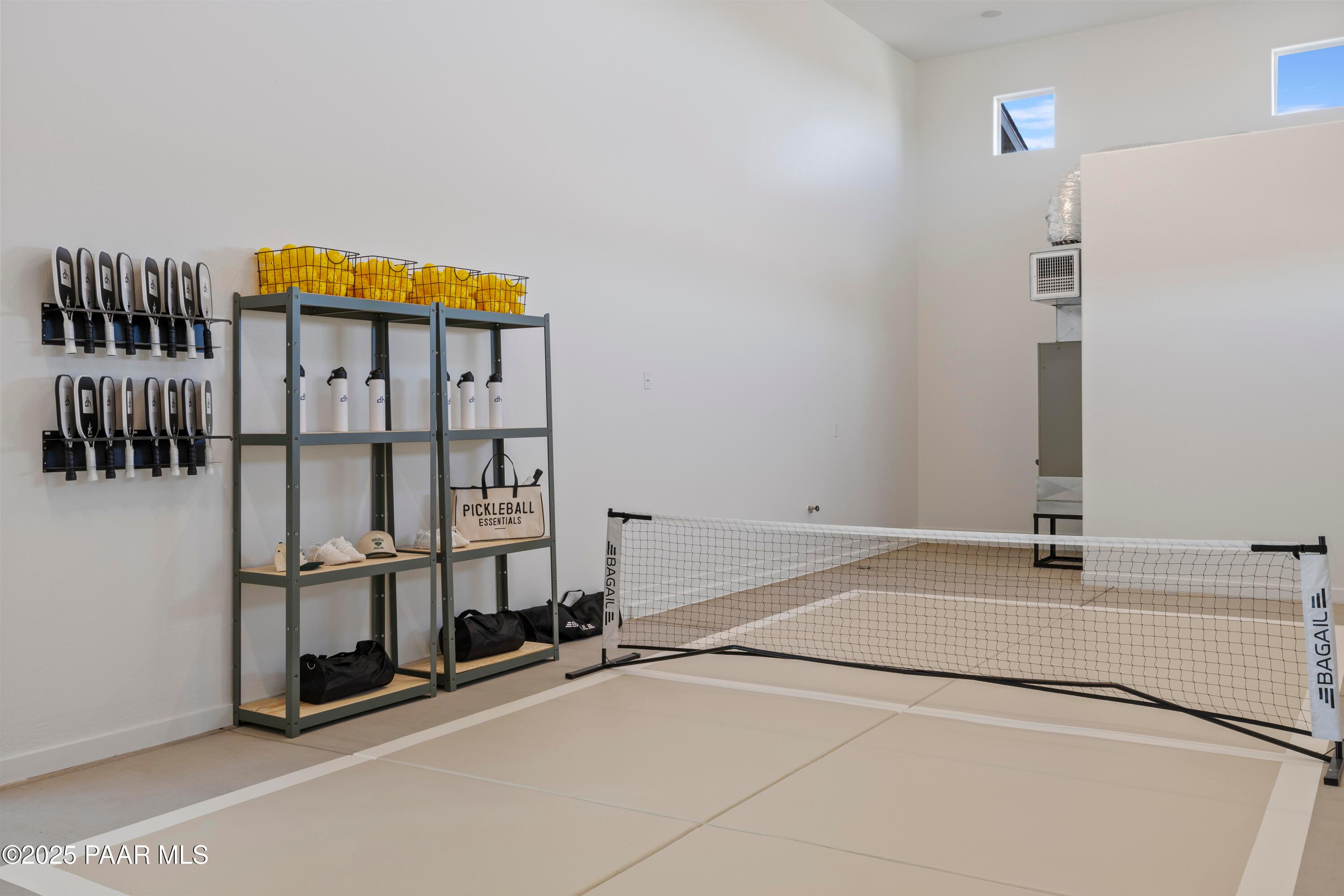 Indoor pickleball court with net, paddles, balls and shelves in Davidson Homes The Blaze D, Hidden Hills, Prescott, AZ