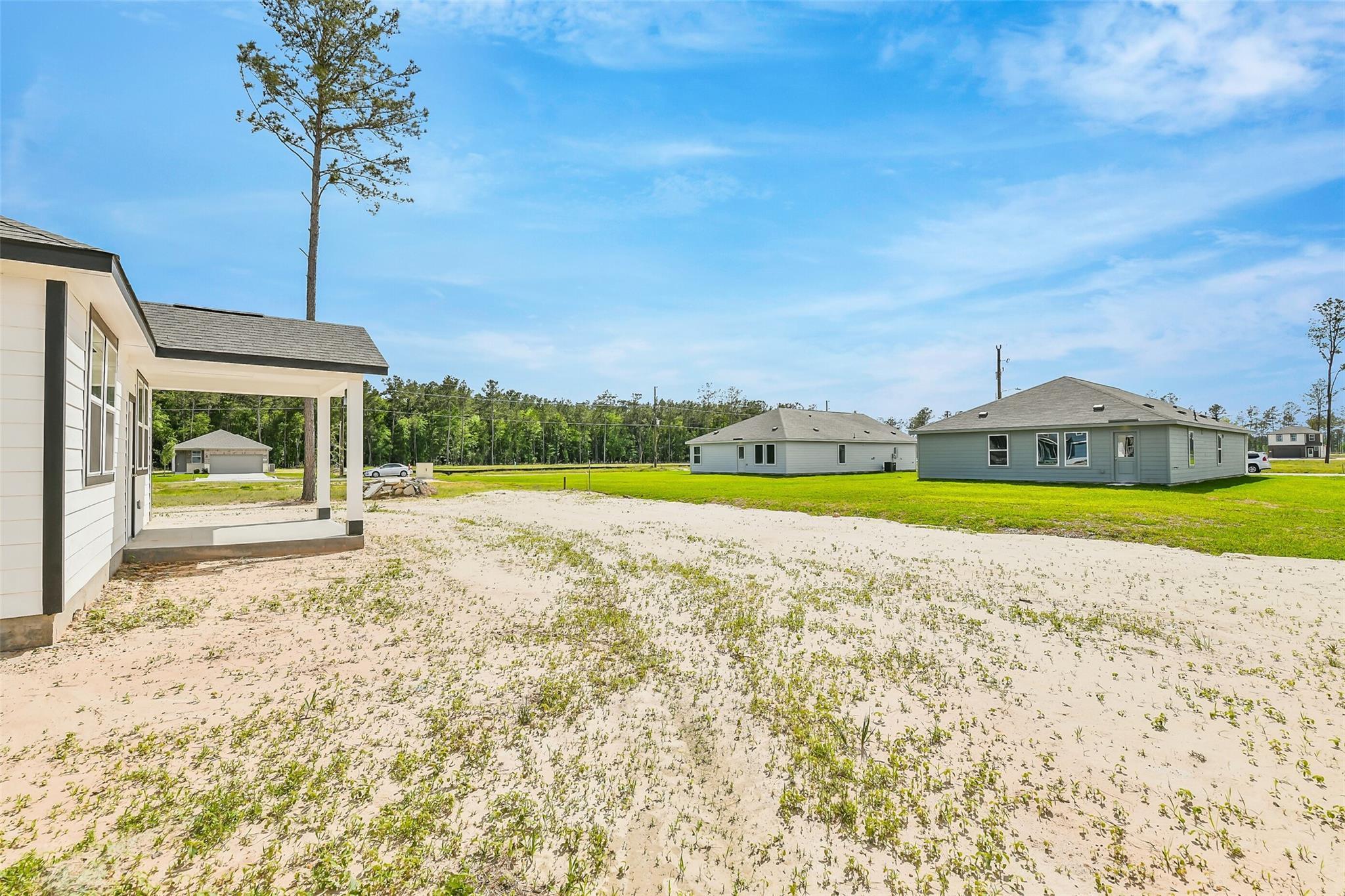 New 3-bedroom Davidson Homes The Frio G with covered porch, 2-car garage, and gravel driveway in Spring Branch Crossing, Conroe, Texas