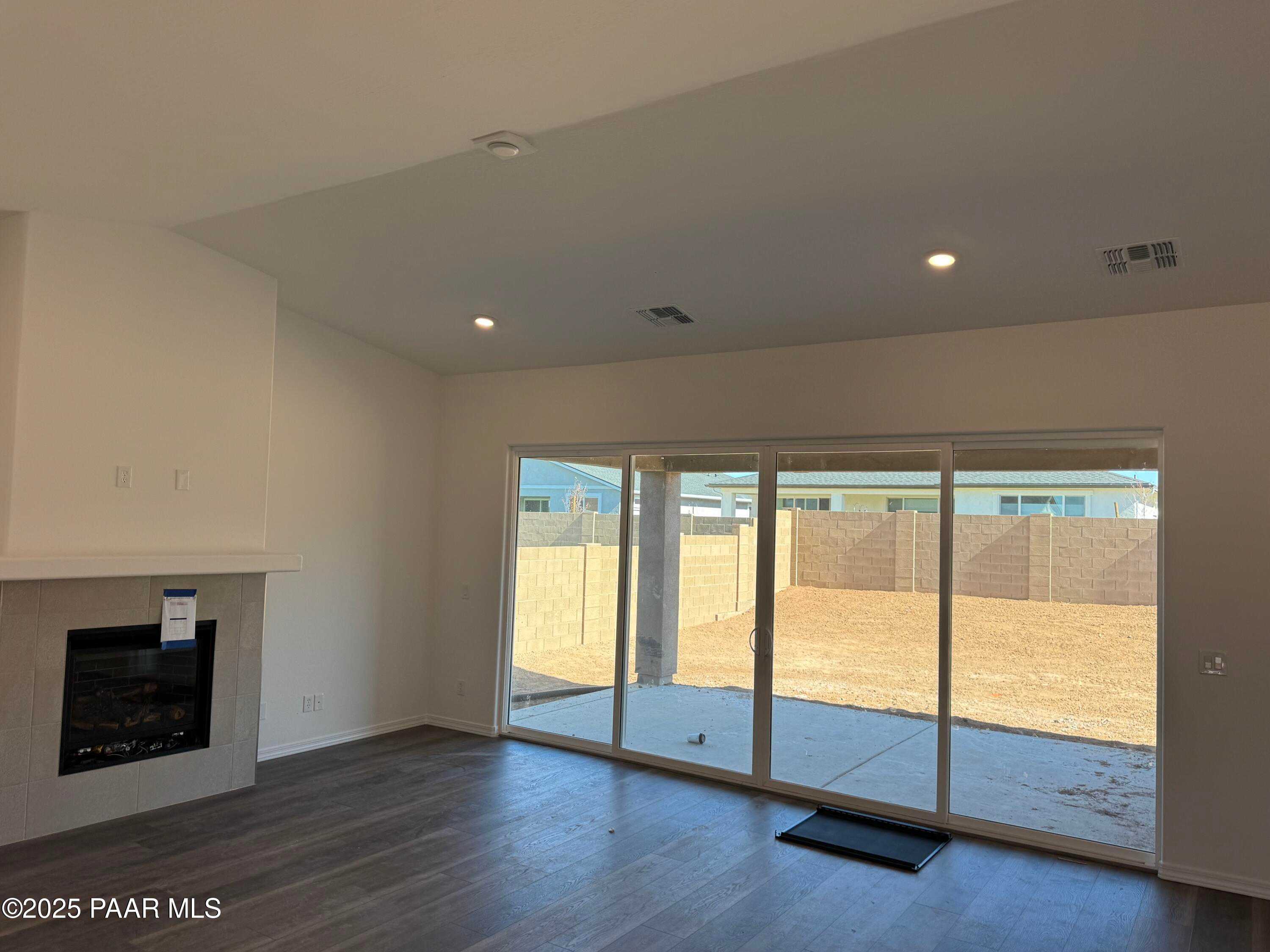 Spacious living room with gas fireplace and sliding glass doors to backyard in Davidson Homes The Sunrise II A, Prescott, Arizona