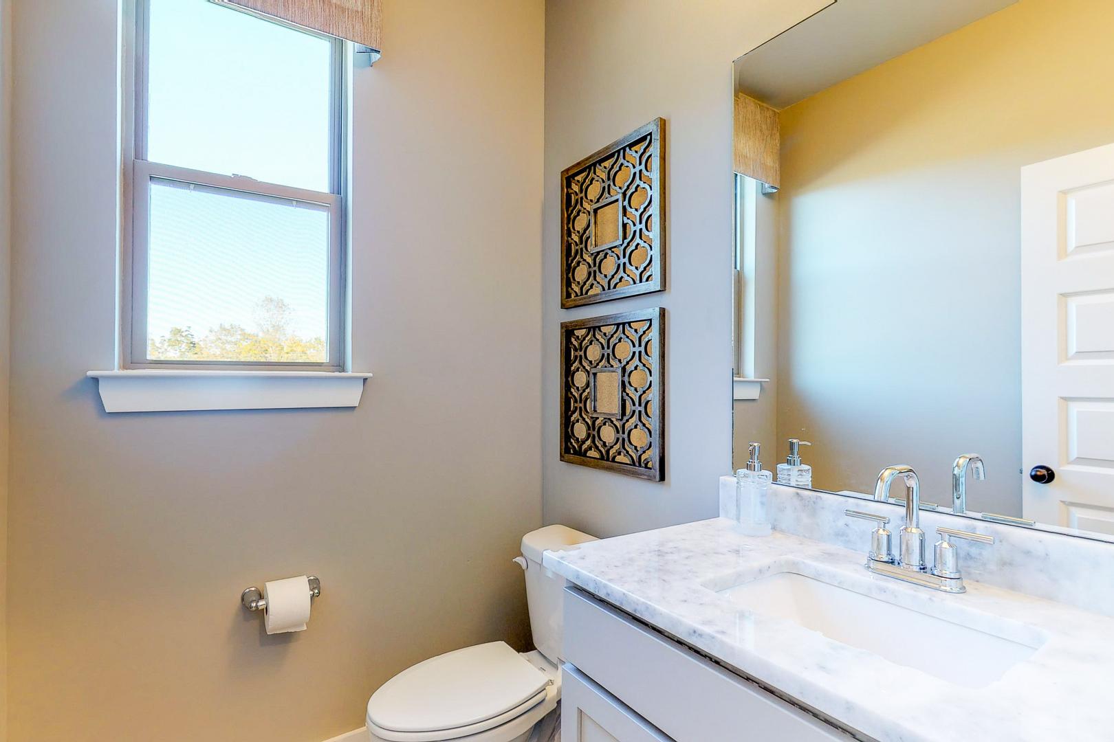 Elegant powder room at Liberty Creek in Gallatin TN with marble vanity, beige walls, large mirror and window
