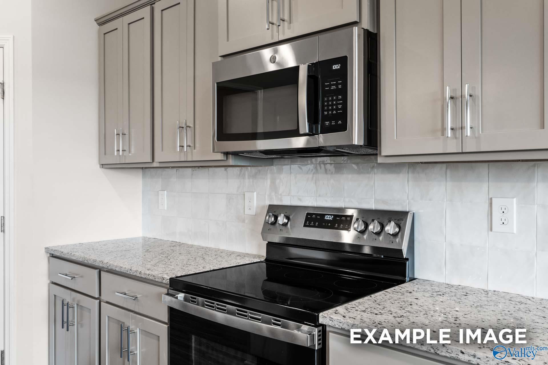 Modern kitchen with granite countertops and stainless steel appliances in The Montgomery B home at The Meadows in Athens, AL.