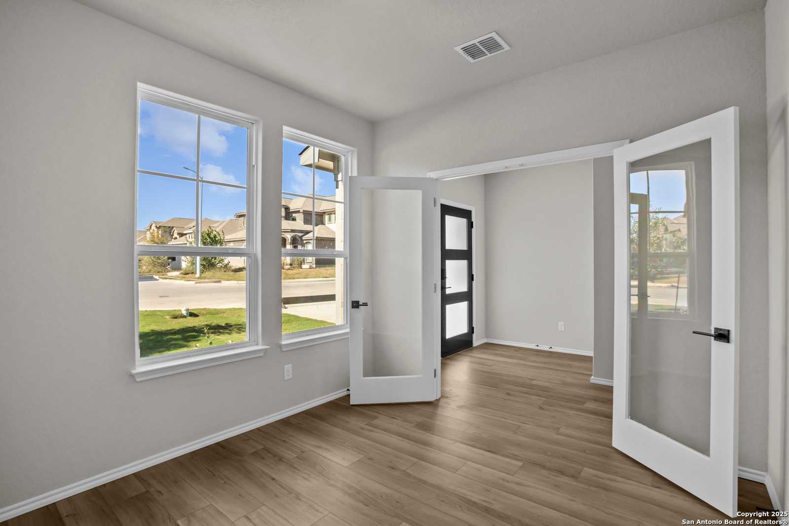 Bright home office with large windows, open French doors, hardwood floors in Davidson Homes The Murray F, Converse, Texas