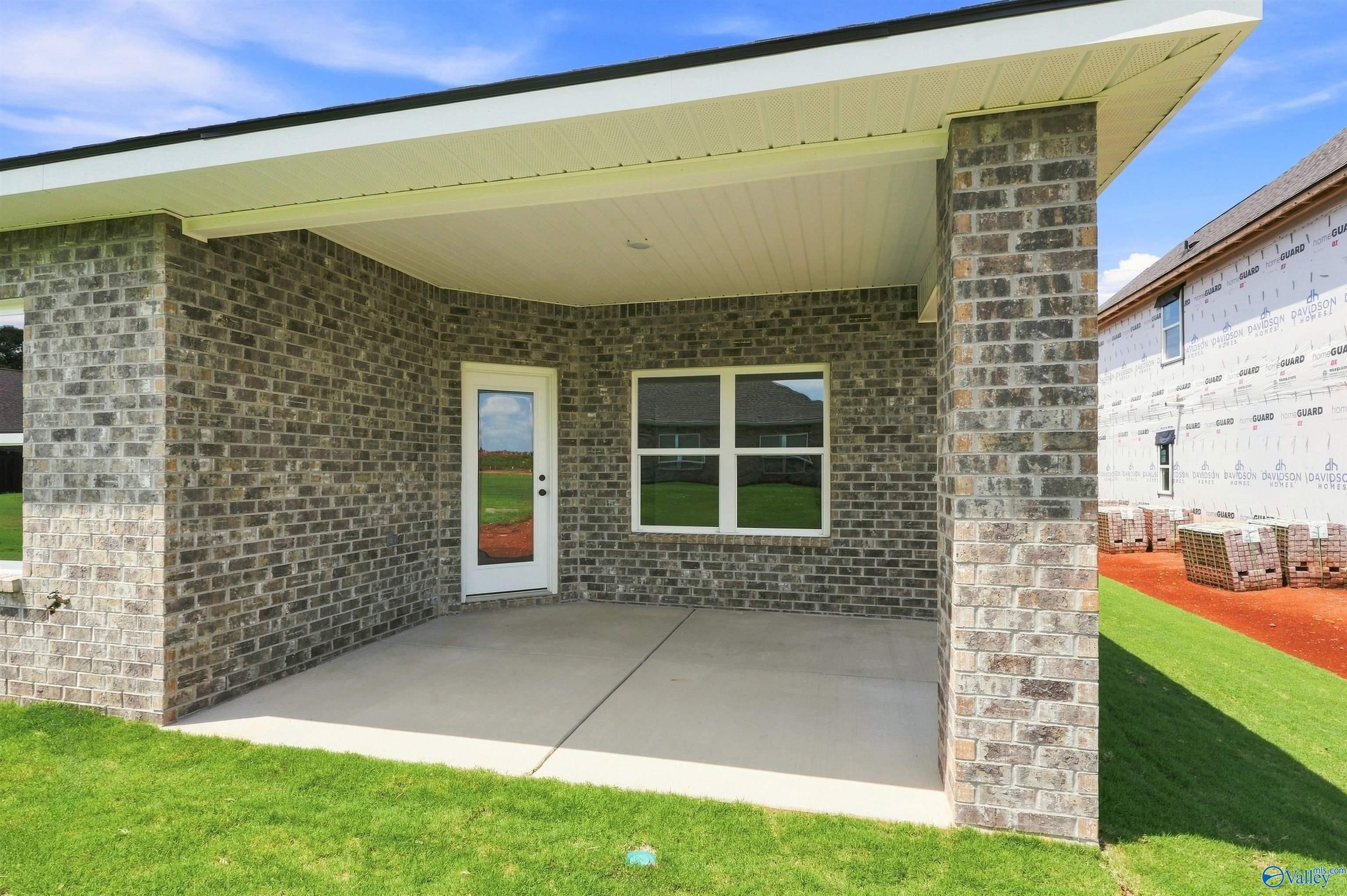 Covered brick patio with glass-paneled door at Davidson Homes Everett B plan in Wood Trail, Toney, Alabama