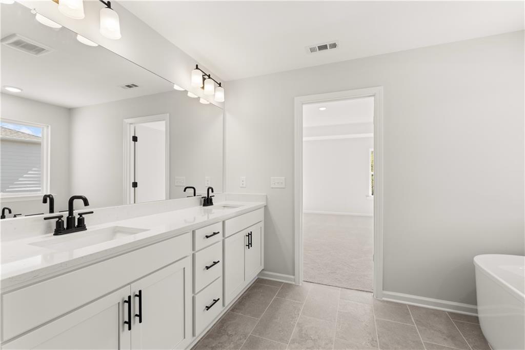 Modern master bathroom with double vanity, quartz countertop, freestanding tub in Davidson Homes The Hickory B, Winder, GA