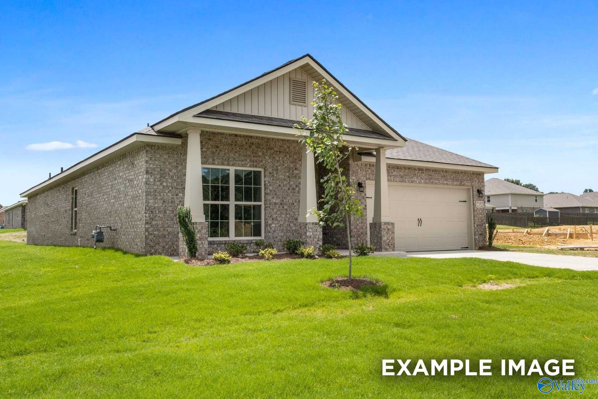 Modern single-story brick home with 2-car garage, gabled roof, and landscaped front yard in The Highlands, Arab, Alabama