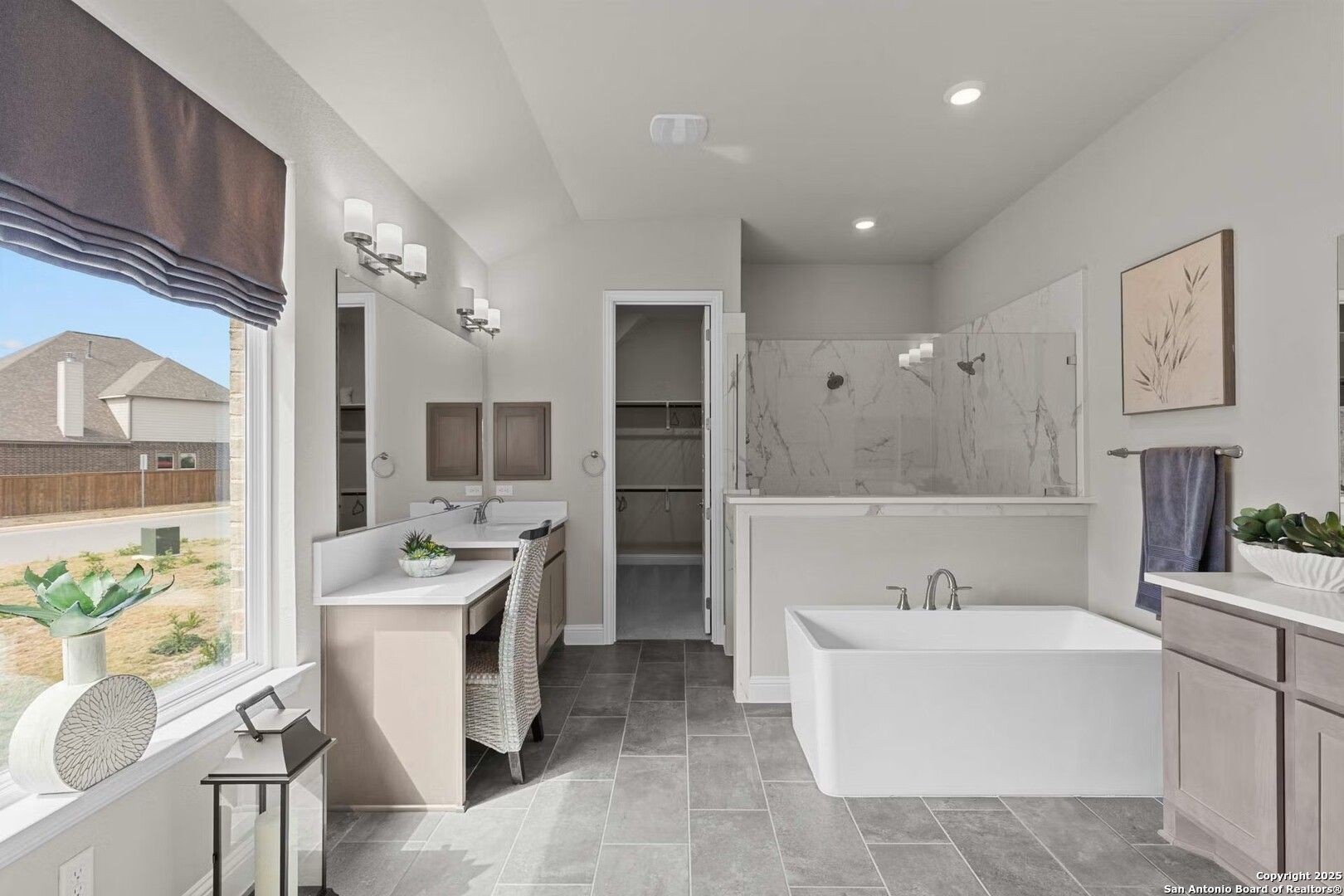 Elegant master bathroom featuring freestanding tub, walk-in shower, double vanity, and large window in Davidson Homes The Garner B, Castroville, Texas