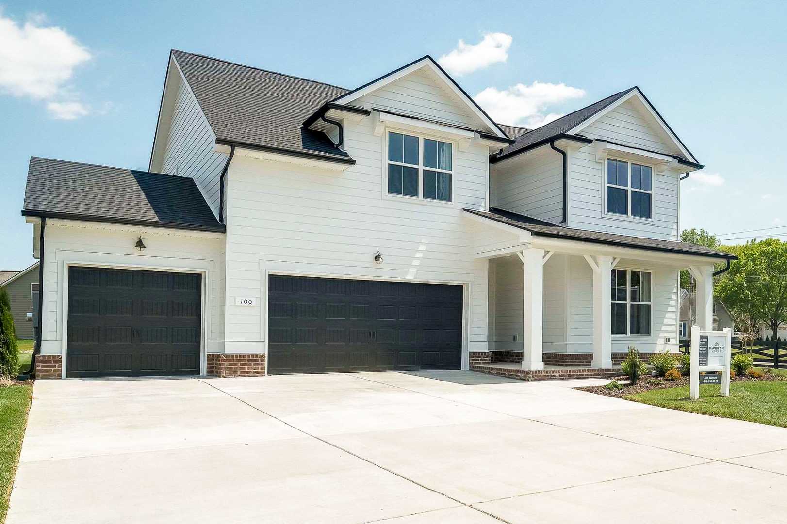 Modern two-story home exterior at The Meadows in Smyrna TN with white siding, covered porch, brick accents, and two-car garage