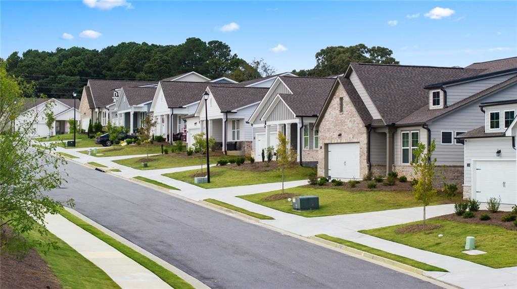 Row of modern 1-story homes with brick accents and 2-car garages in Kelly Preserve, Loganville, Georgia by Davidson Homes