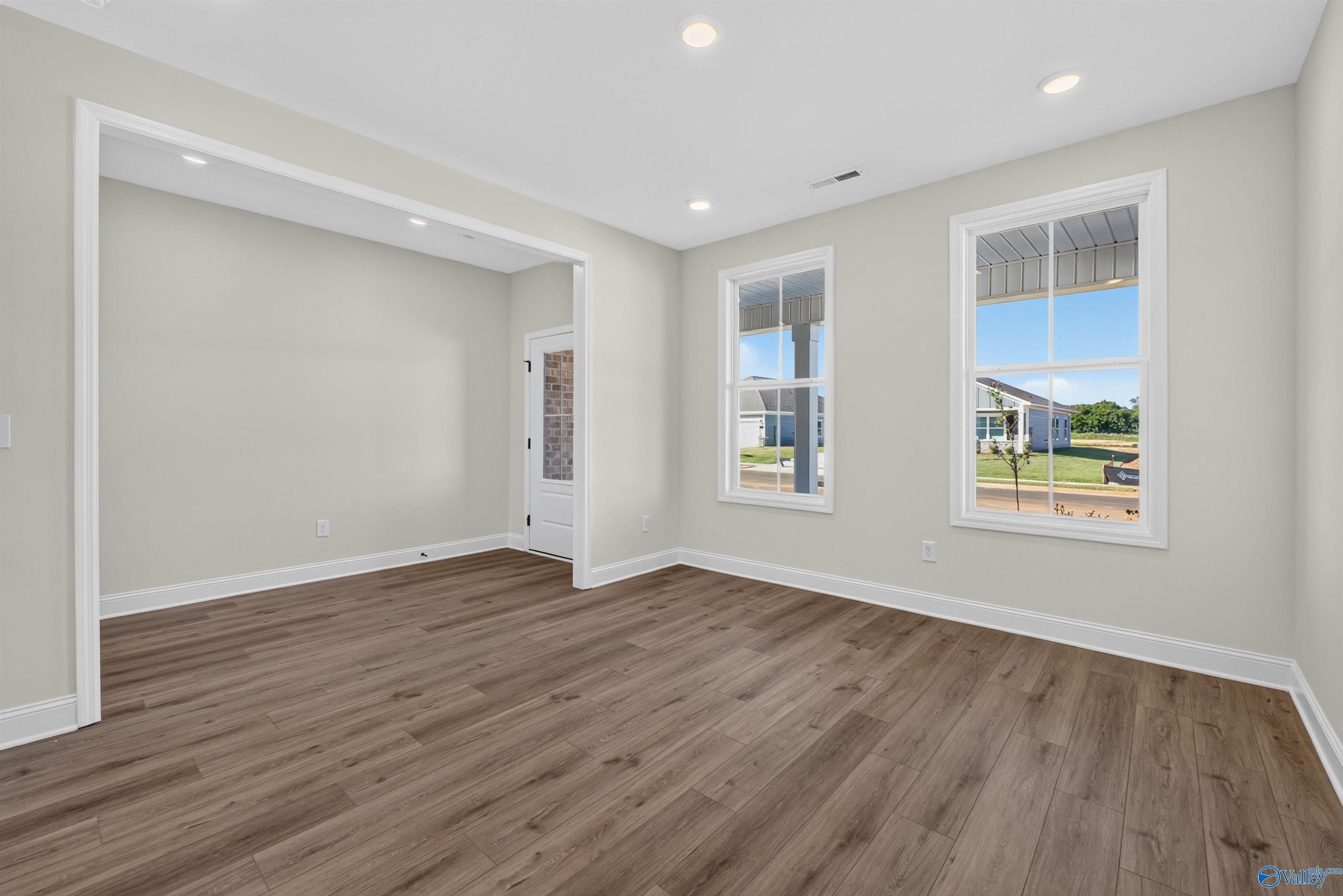Bright dining room with luxury vinyl plank flooring, recessed lighting, and windows overlooking front yard in Davidson Homes Ashport L plan