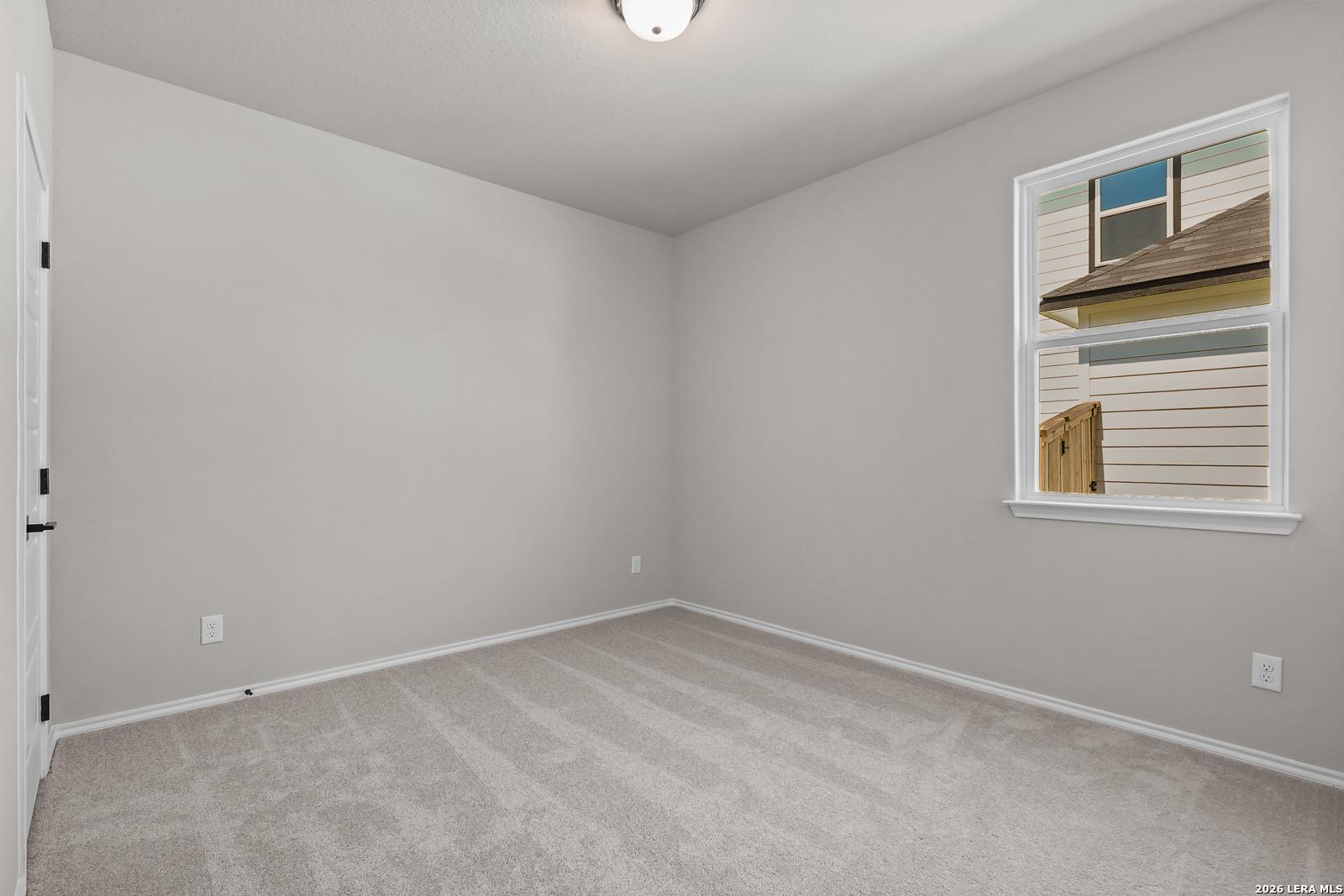 Neutral-toned bedroom with plush carpet in The Daphne H floor plan by Davidson Homes in Hannah Heights, Seguin, Texas.