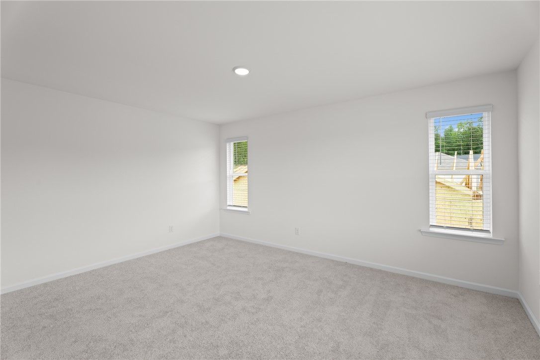 Bright, spacious bedroom with neutral carpet in The Stella D floor plan by Evermore Homes in Silver Oak, Cusseta, Alabama.