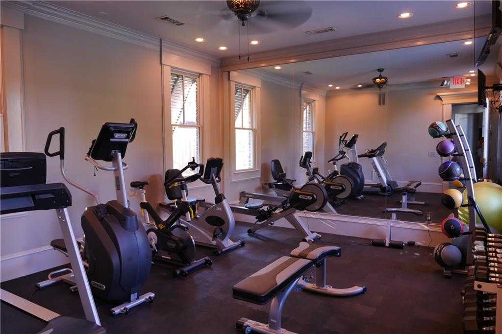Well-equipped home gym with treadmills, ellipticals, bikes, weights, and mirrors in Davidson Homes Seaside B, Woodstock, GA