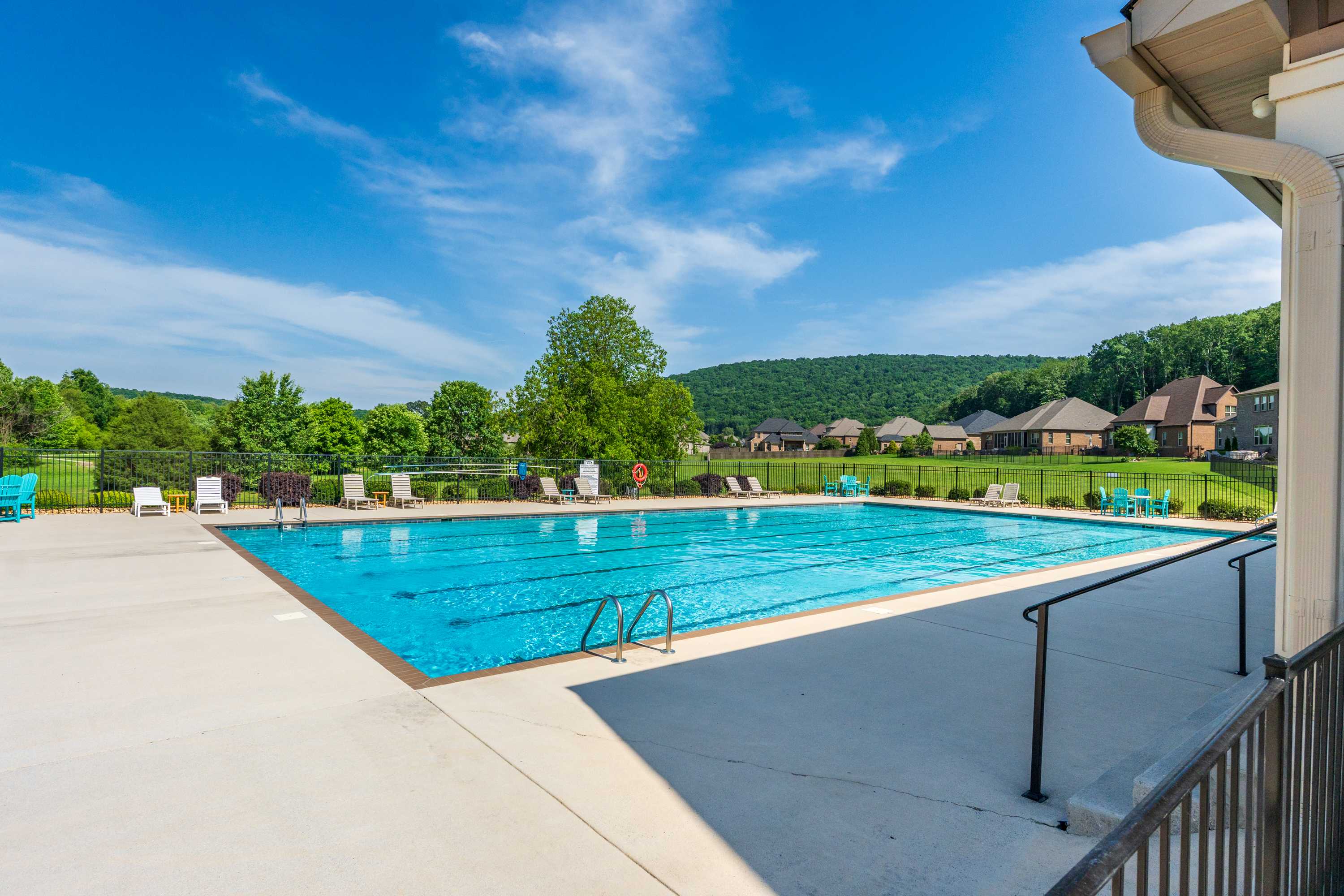 Resort-style swimming pool at The Meadows at Hampton Cove in Owens Cross Roads Alabama with lounge chairs and wooded hillside views