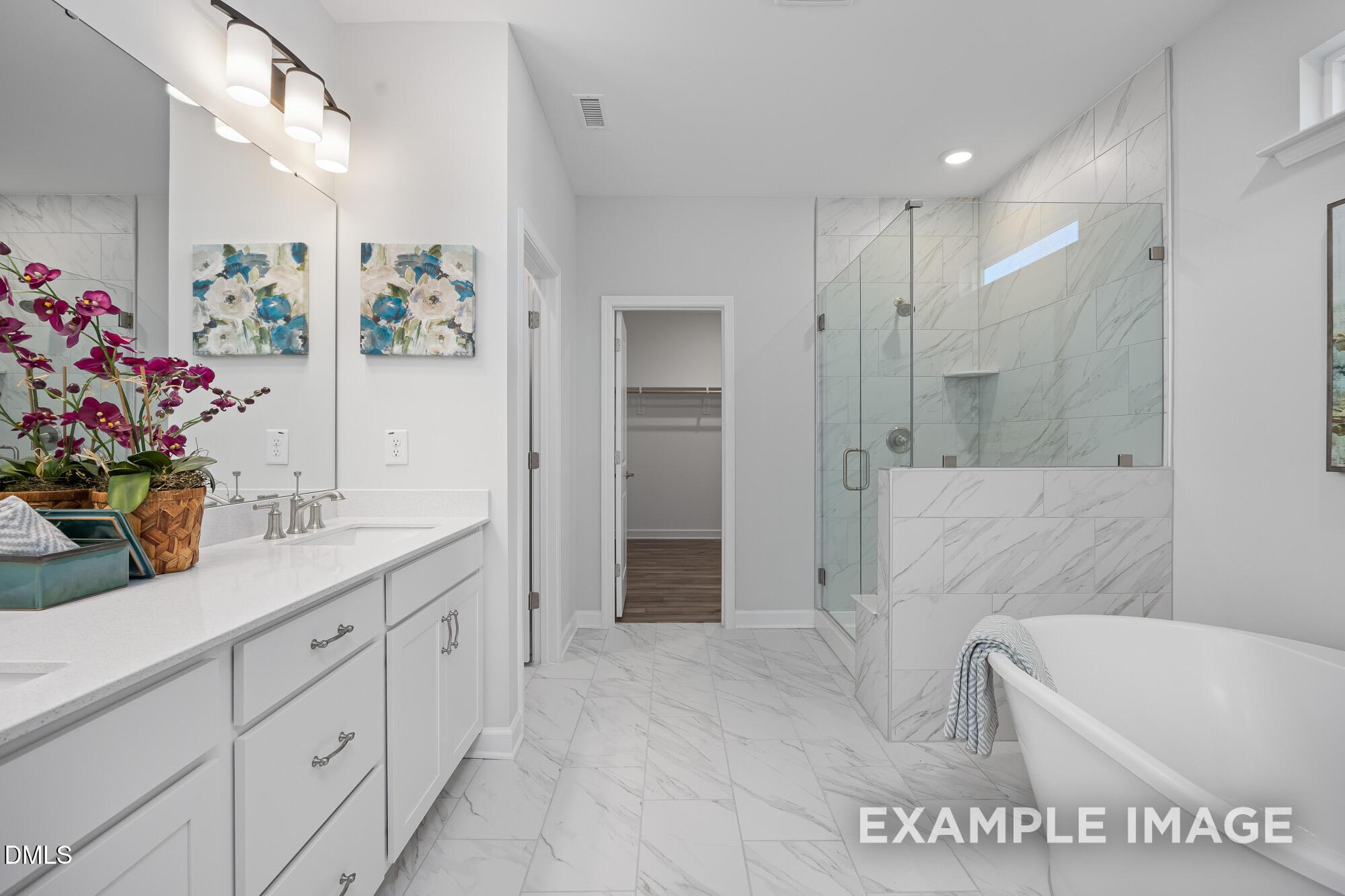 Luxurious master bathroom with freestanding tub, glass shower, double vanity in Davidson Homes The Cypress B II, Angier, NC