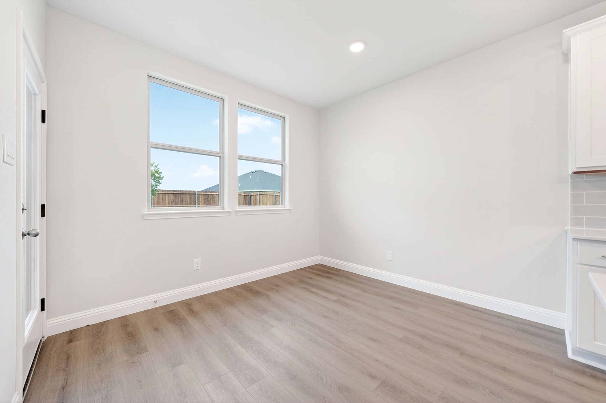 Bright breakfast nook in The Redbud floor plan featuring light wood-tone flooring and access to the backyard.
