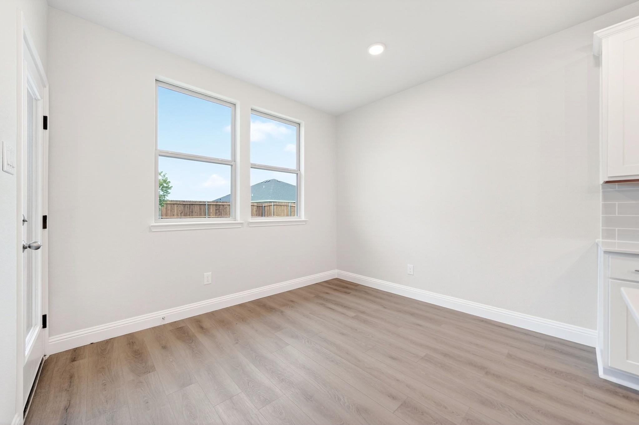 Bright breakfast nook in The Redbud floor plan featuring light wood-tone flooring and access to the backyard.
