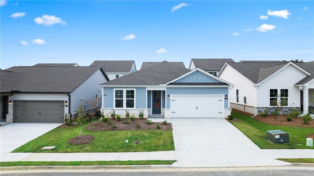 Modern 1-story Daphne C home exterior by Davidson Homes in Kelly Preserve, Loganville, GA: white siding, blue door, 2-car garage, landscaped yard