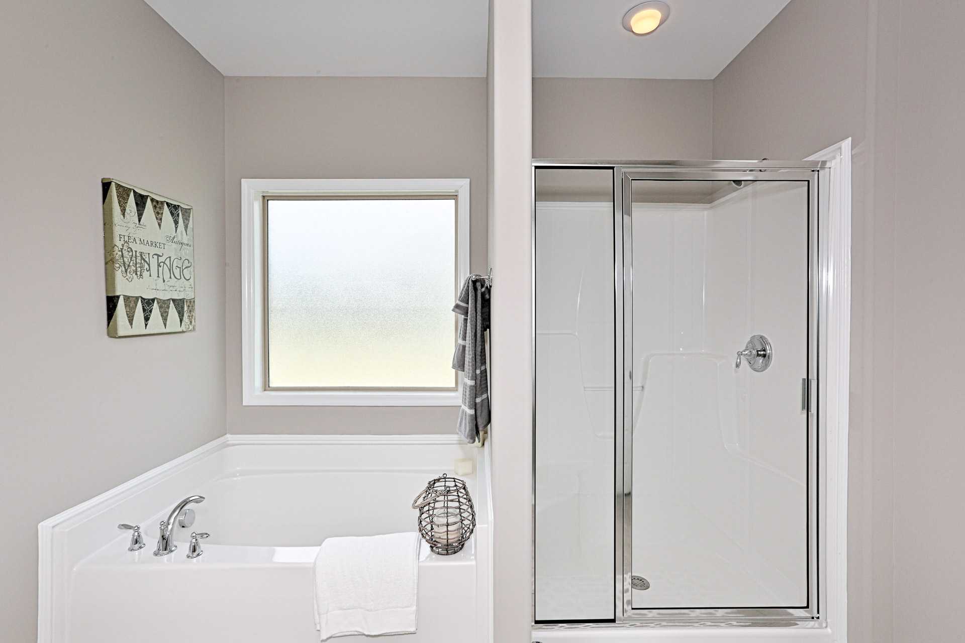 Spacious master bathroom at Stone Creek Phase II in Cullman Alabama with bathtub, glass shower, and neutral tones